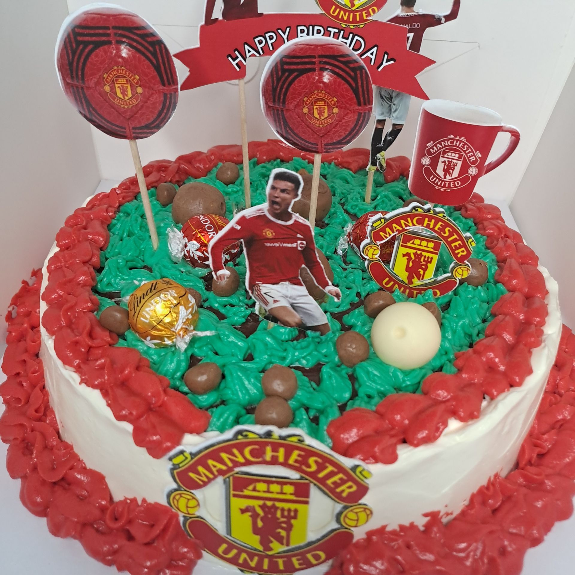 A manchester united birthday cake with red and green frosting