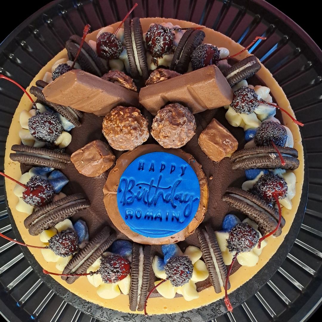 A birthday cake with a blue cookie that says happy birthday