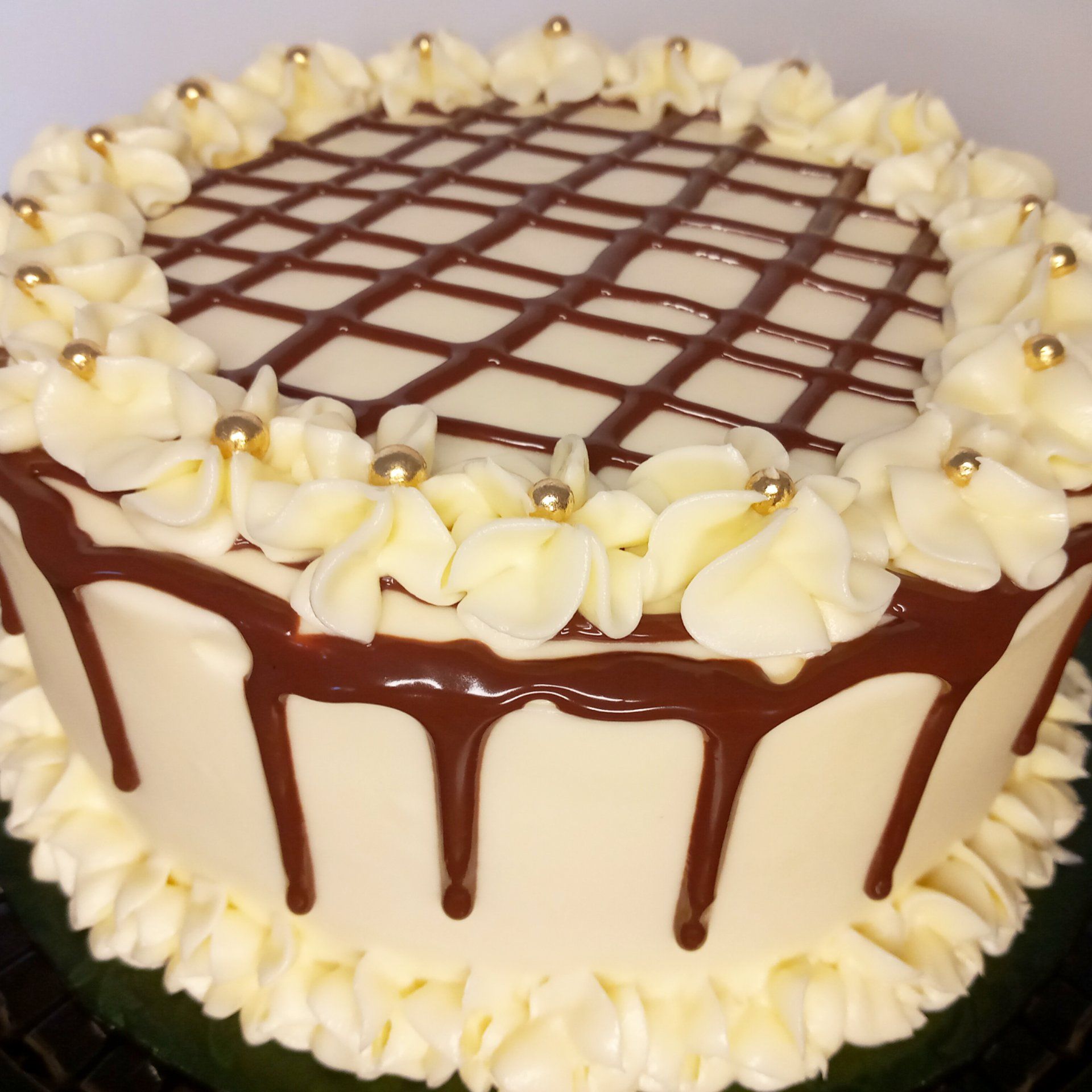 A white cake with chocolate frosting and flowers on top