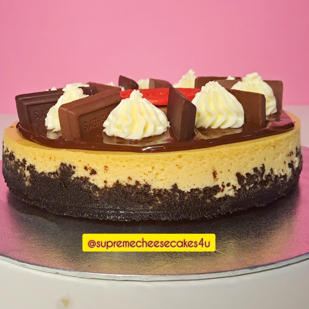 A supreme cheesecake with chocolate and whipped cream on top