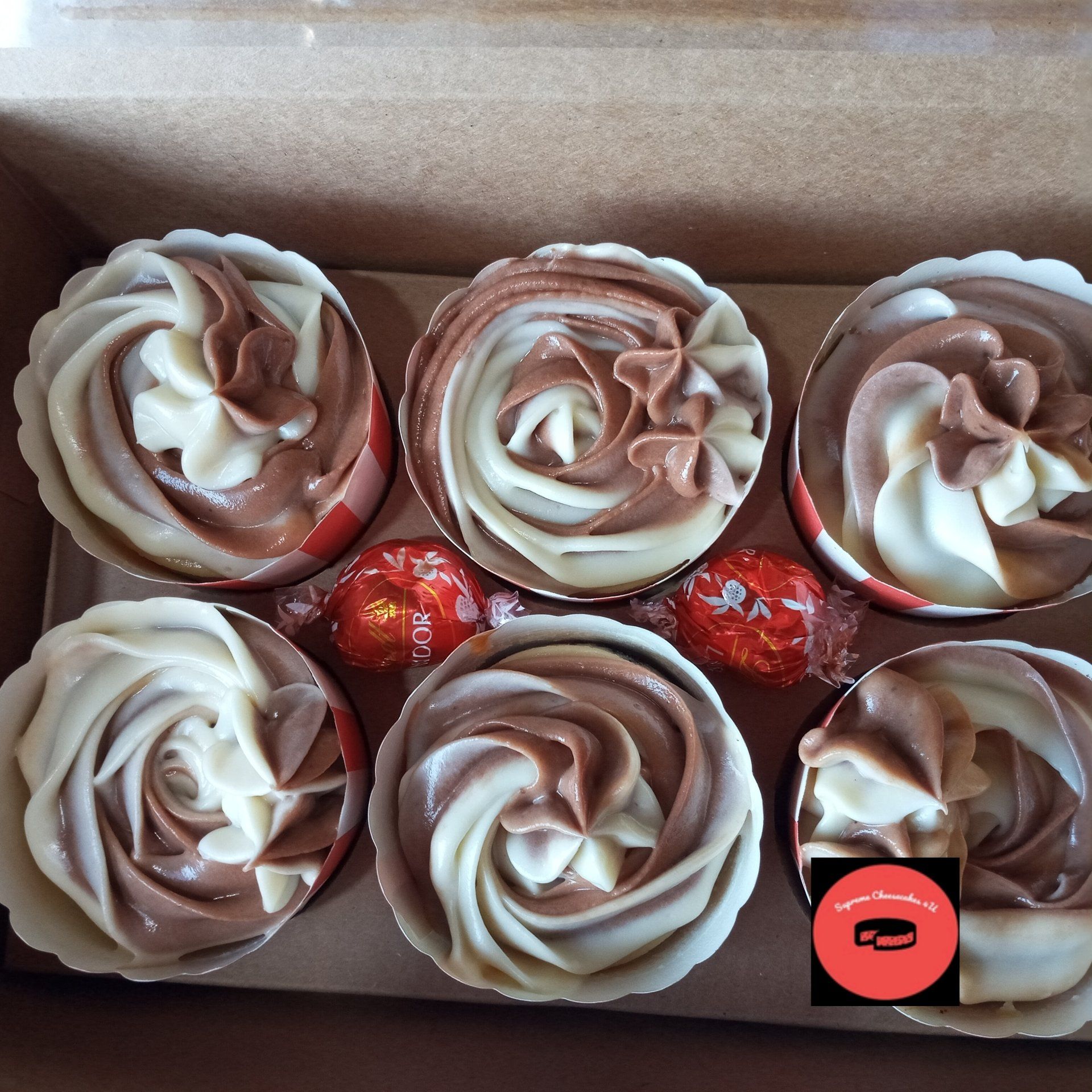 A box of chocolate frosted cupcakes with lindt candies