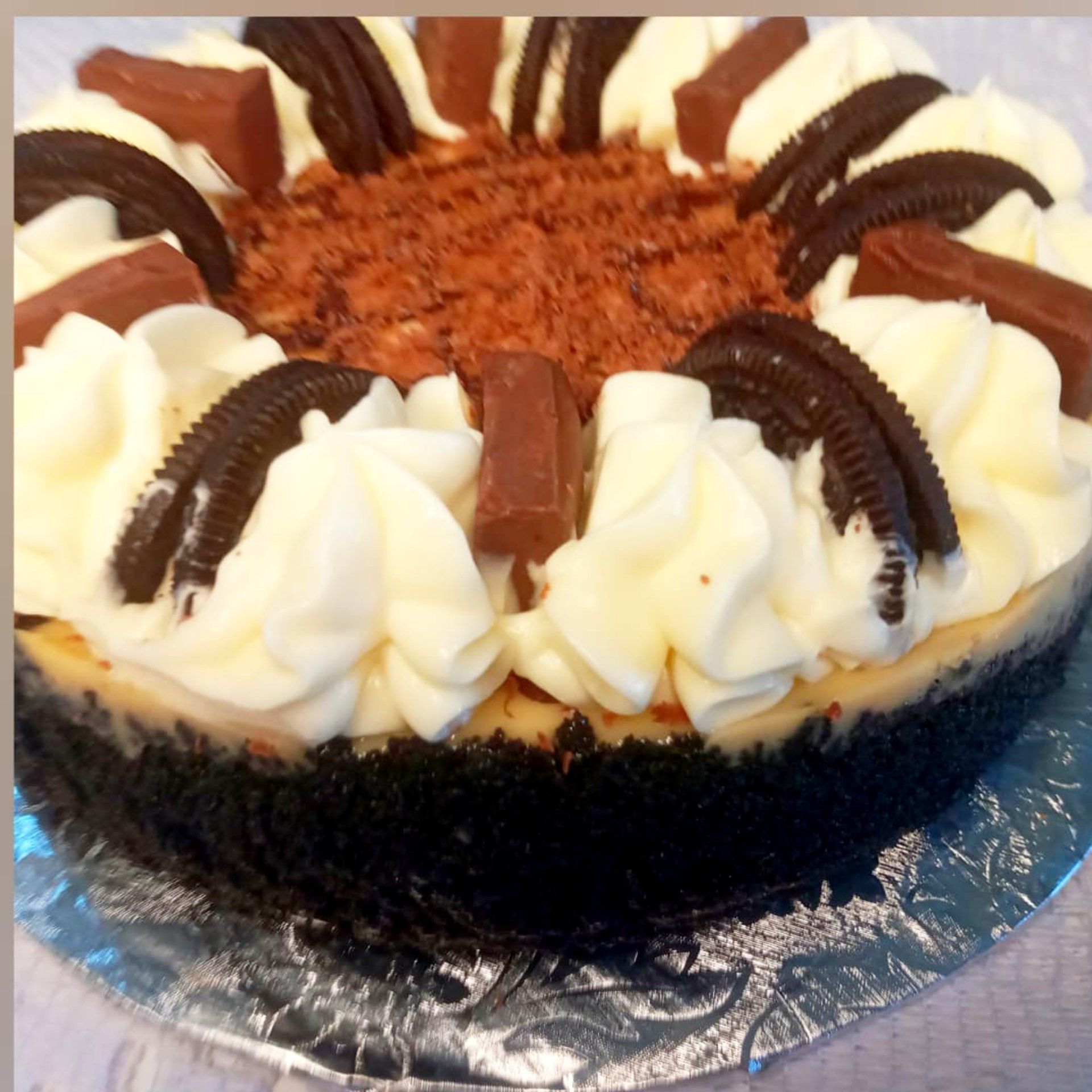 A cheesecake with whipped cream and oreos on top