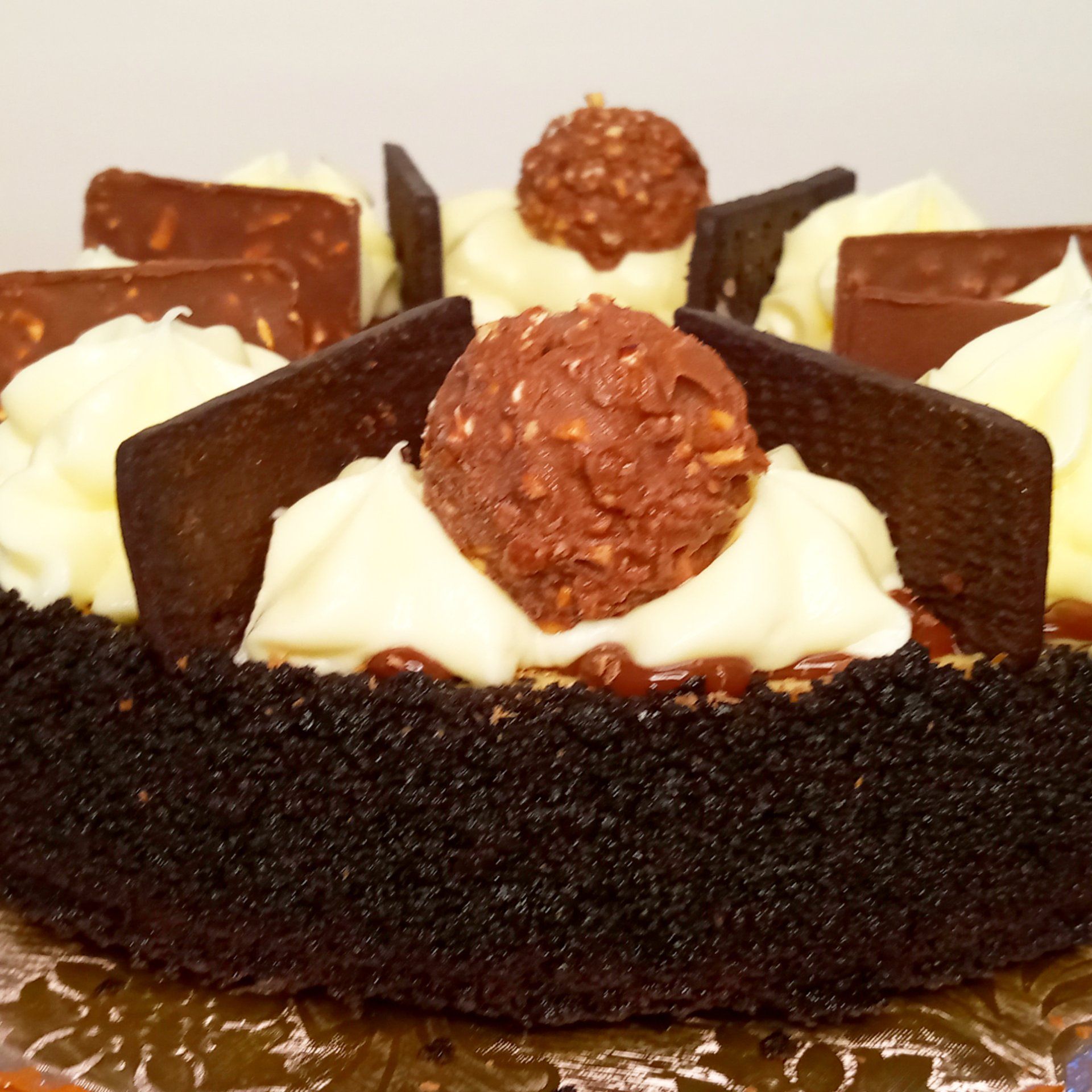 A chocolate cake with whipped cream and chocolate shavings on top