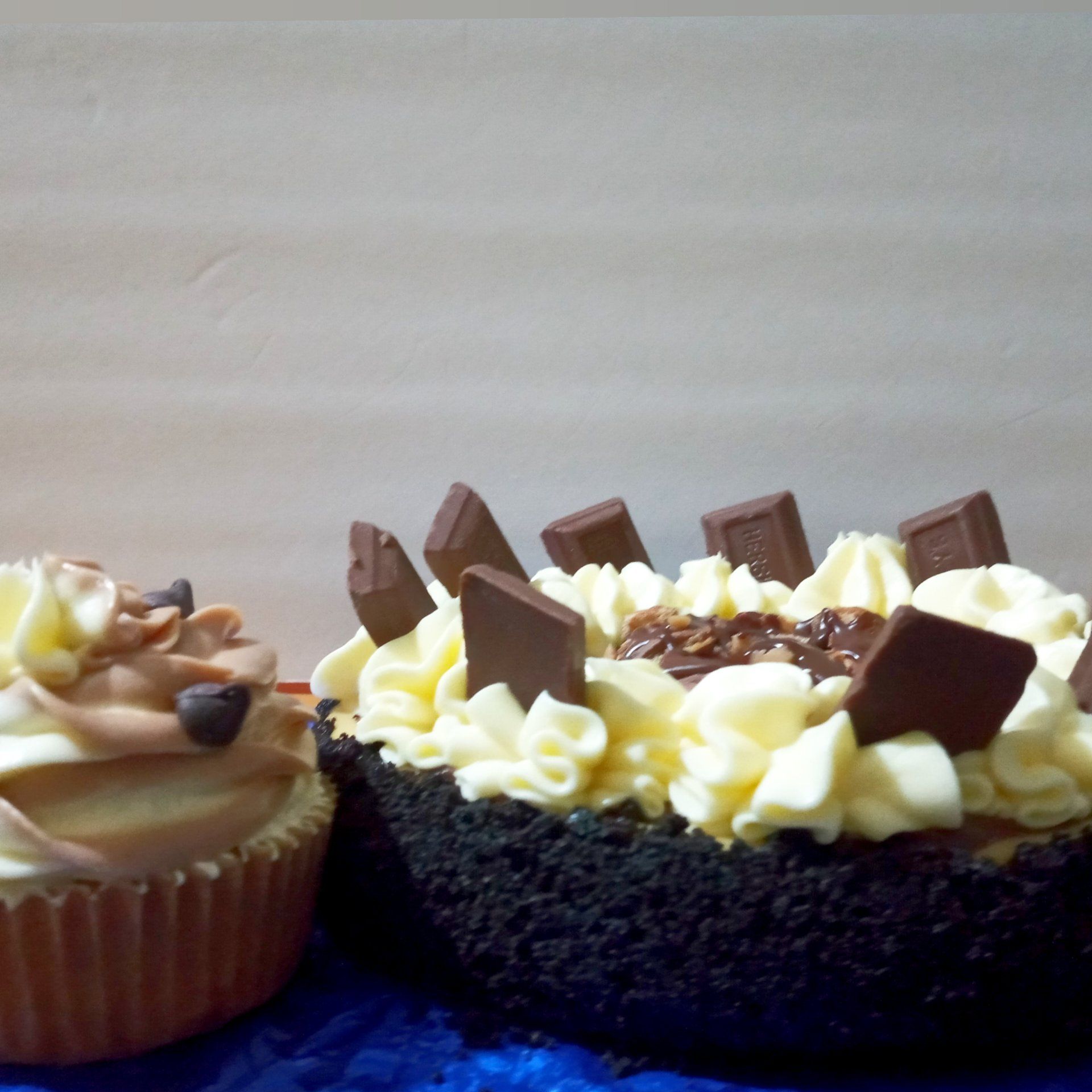 Two cupcakes are sitting next to each other on a table