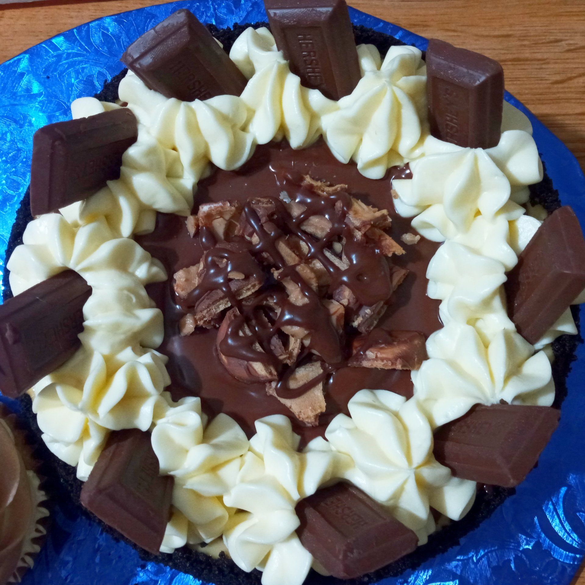 A chocolate cake with whipped cream and hershey bars on top