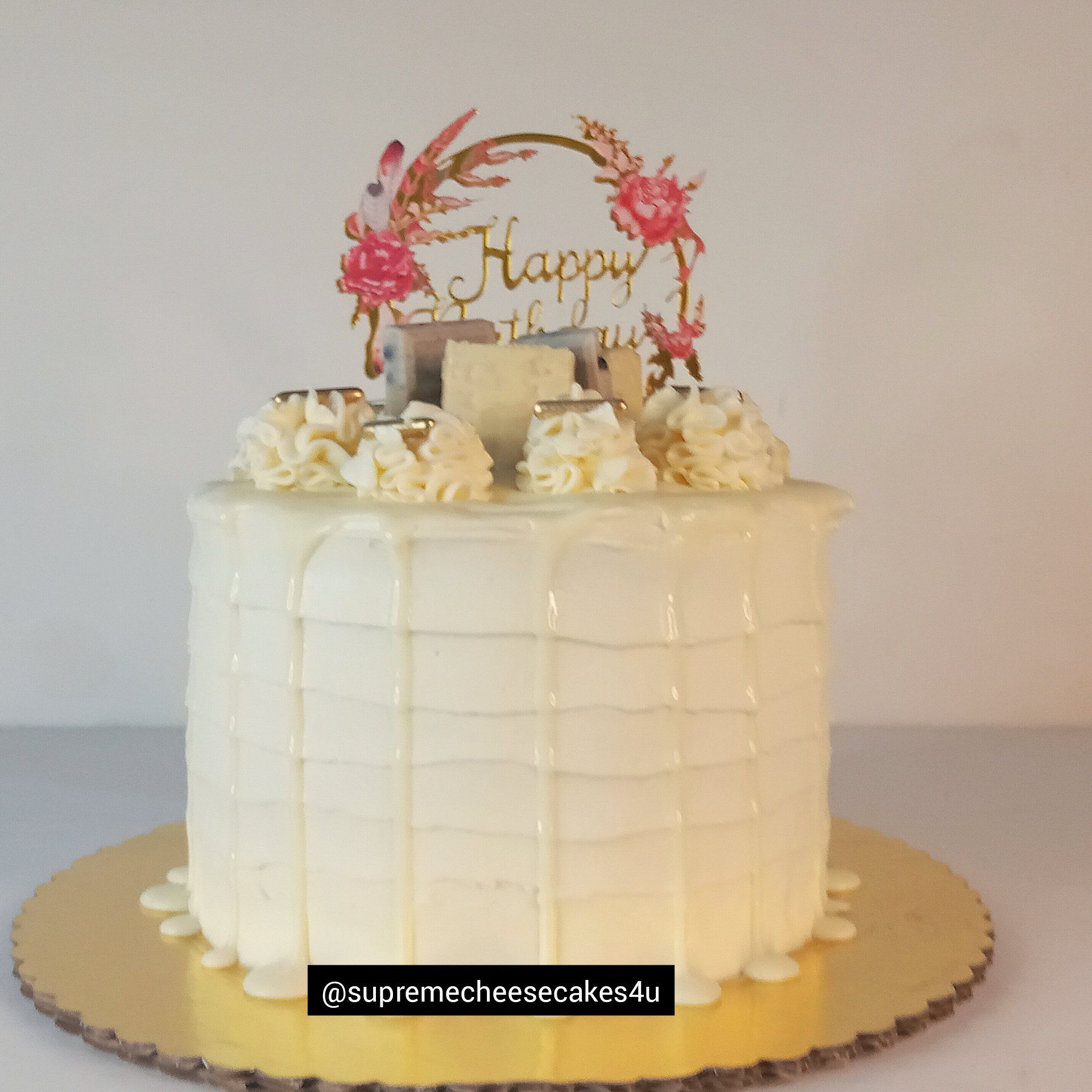 A white cake with a happy birthday topper on top