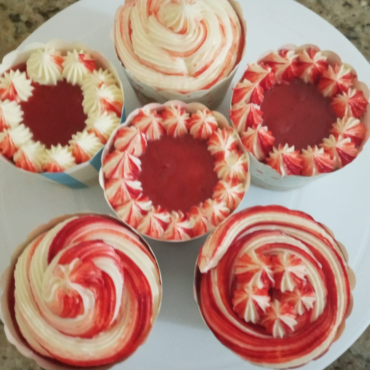 Cupcakes with red and white frosting on a white plate