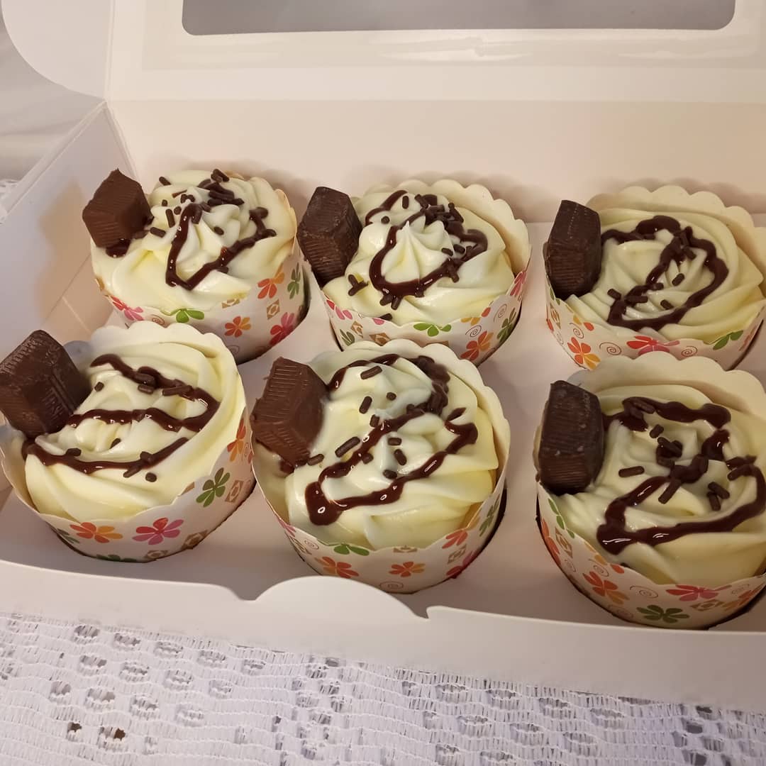 A box of cupcakes with frosting and chocolate sprinkles