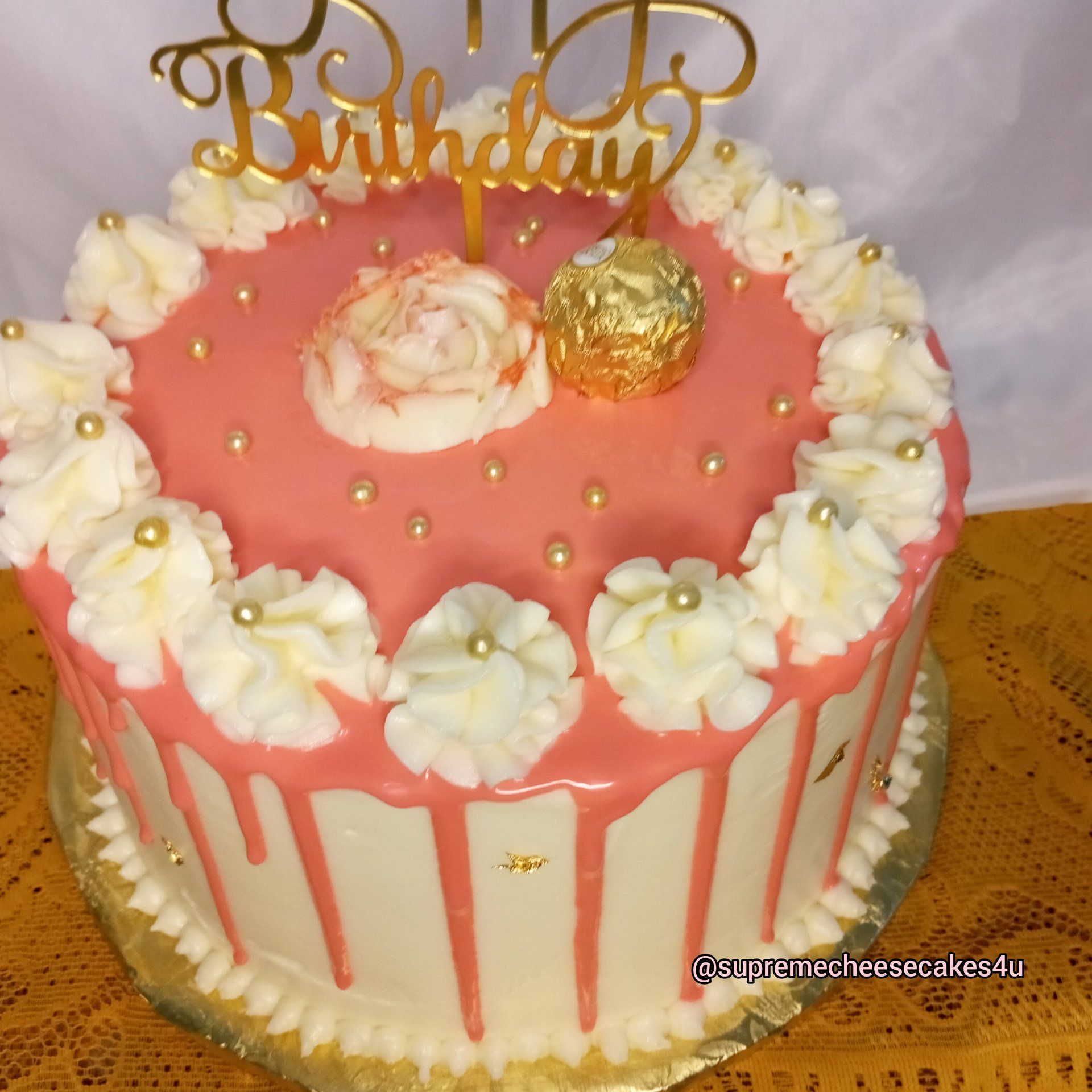 A birthday cake with pink frosting and white frosting