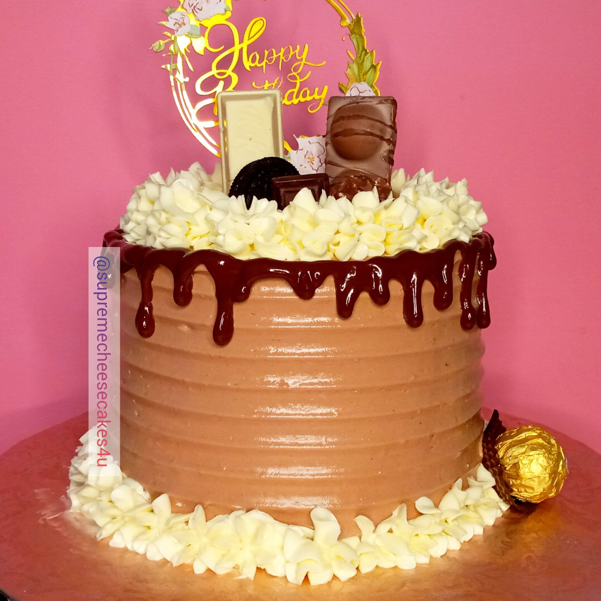 A chocolate cake with white frosting and a happy birthday topper
