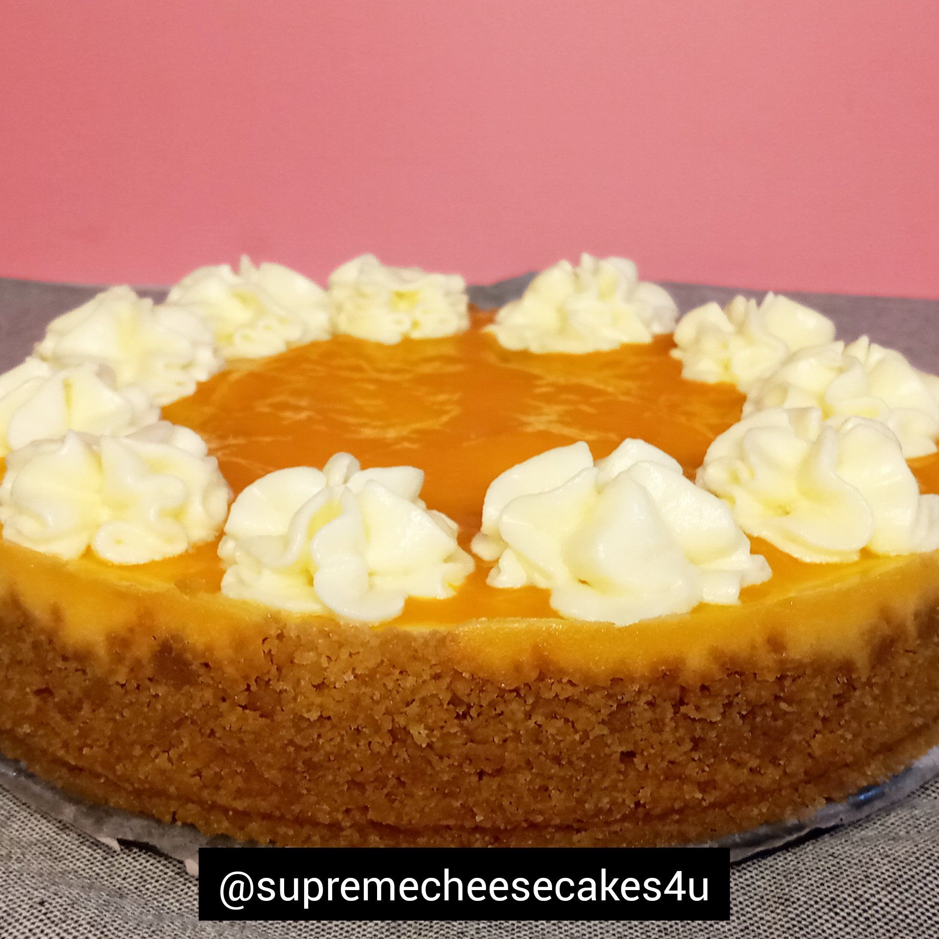 A cheesecake with whipped cream on top is sitting on a table.
