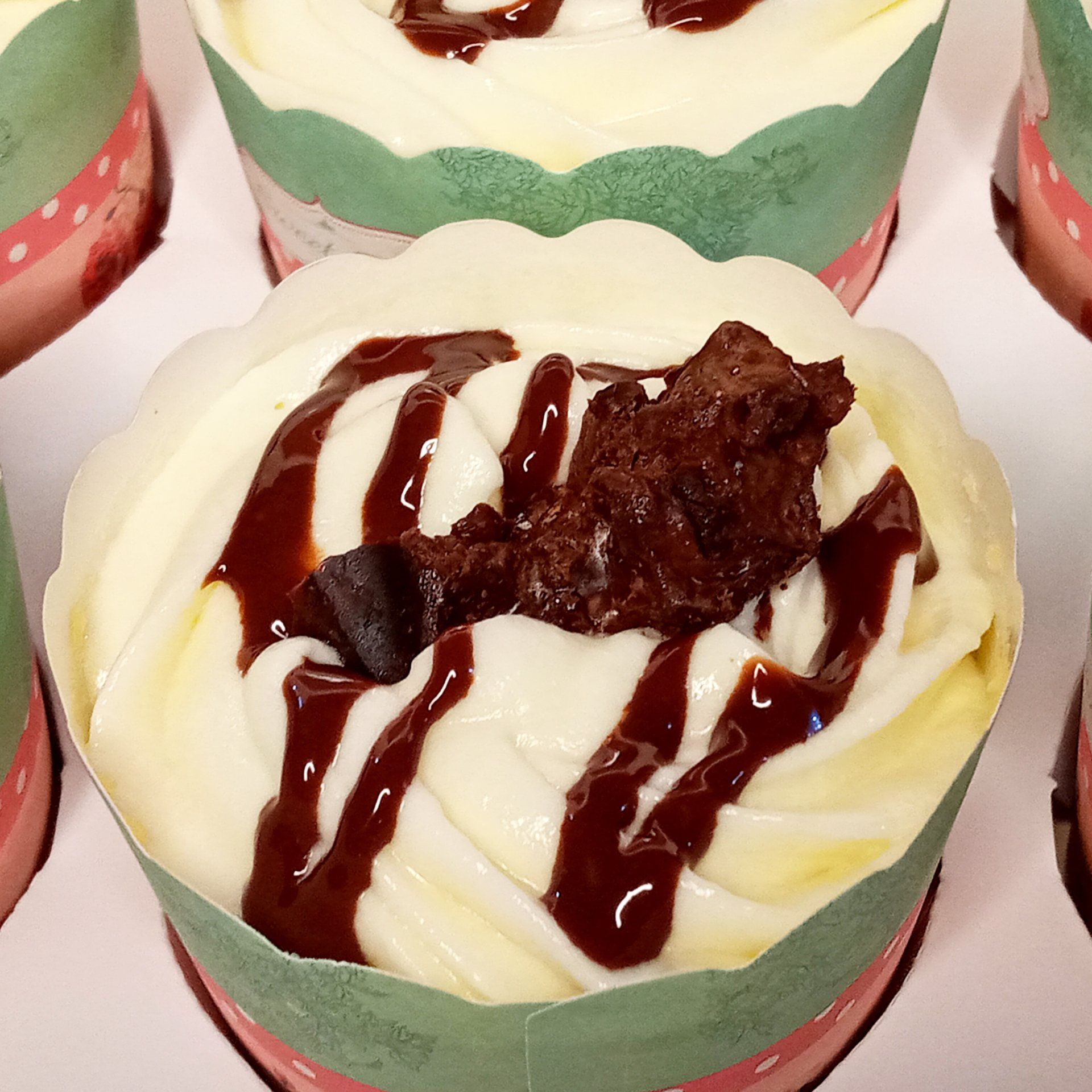 A close up of a cupcake with chocolate sauce on top