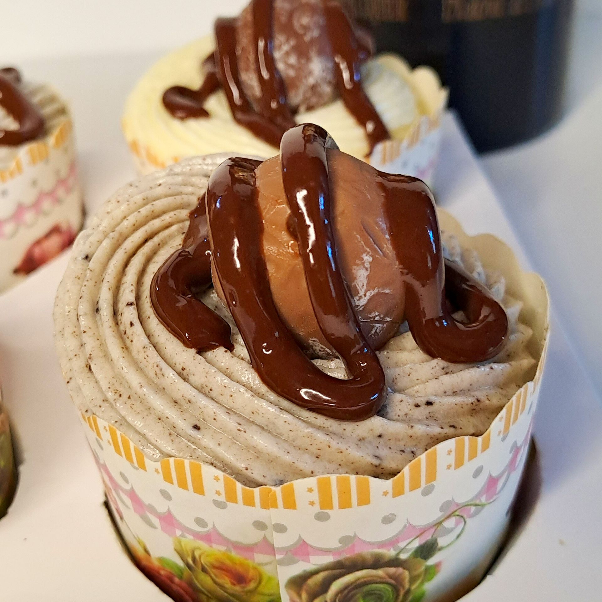 A close up of a cupcake with chocolate frosting on top