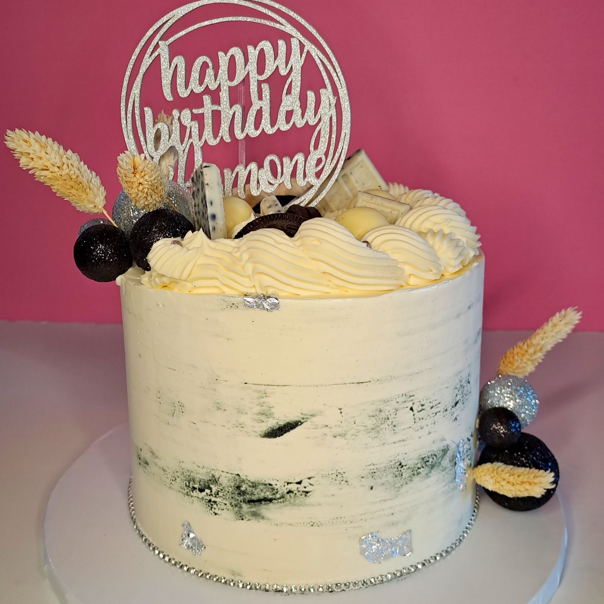 A cake with a happy birthday topper on top of it