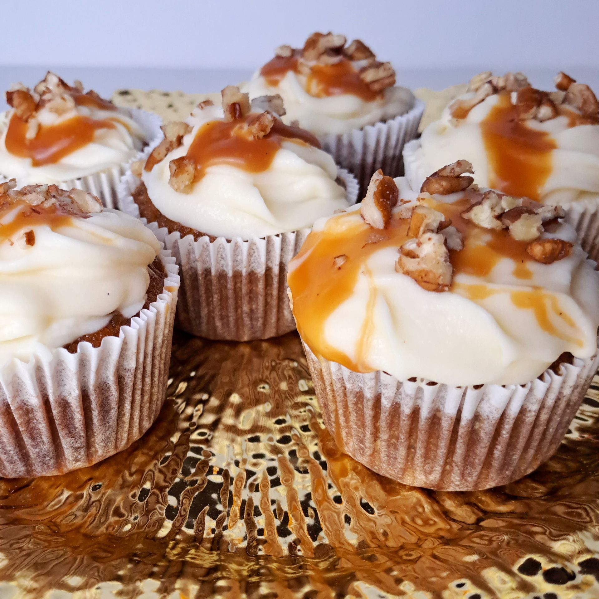 A bunch of cupcakes with frosting and caramel on top