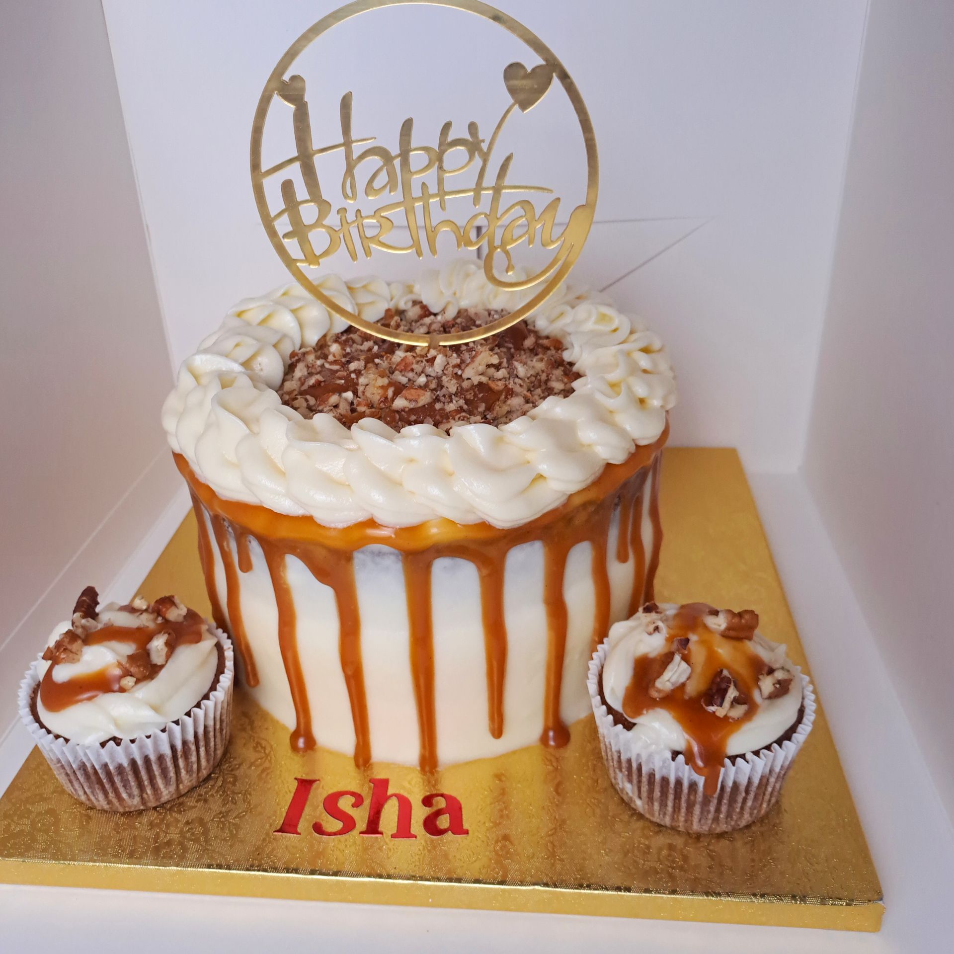 A birthday cake with cupcakes and a happy birthday topper