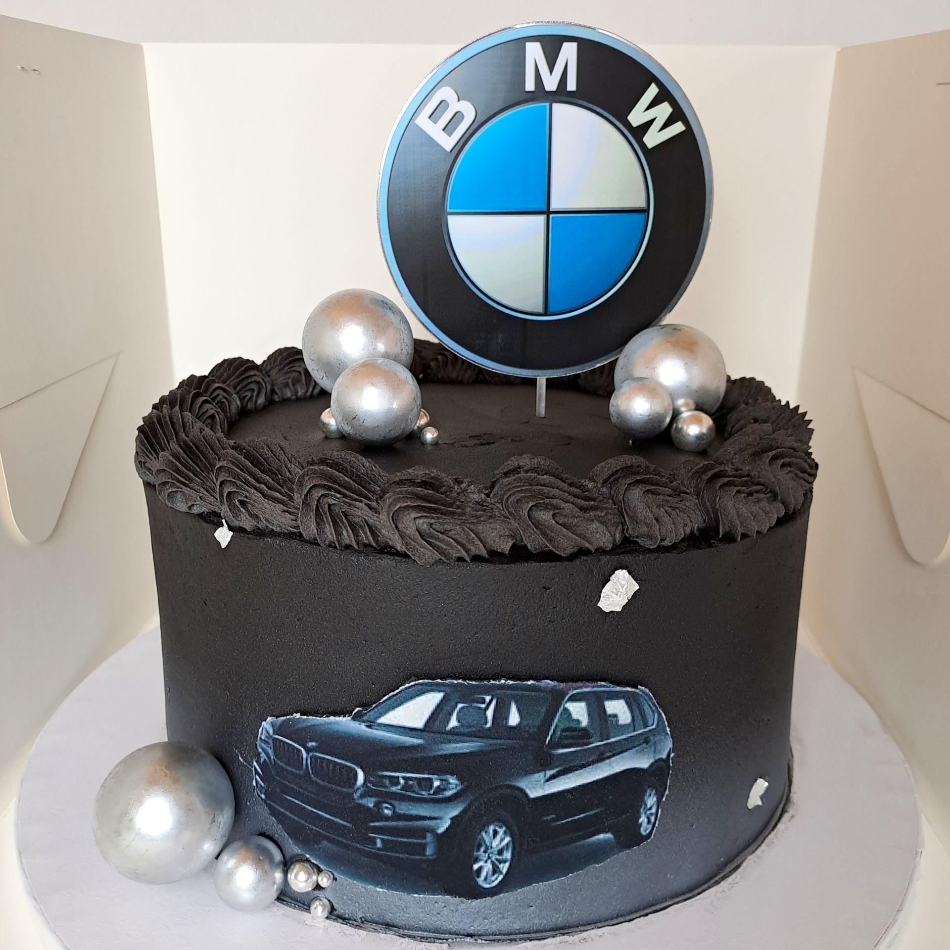 A black cake with a bmw logo on top