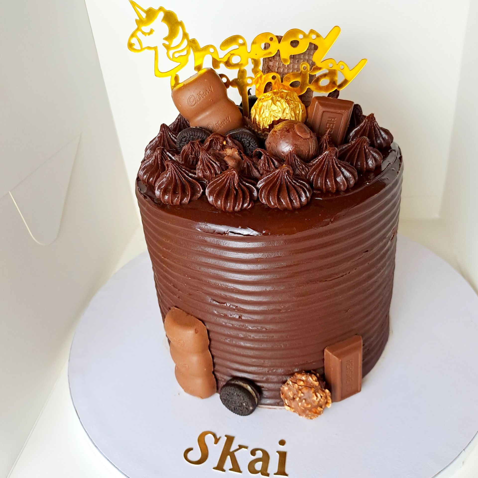 A chocolate cake with the name skai on it