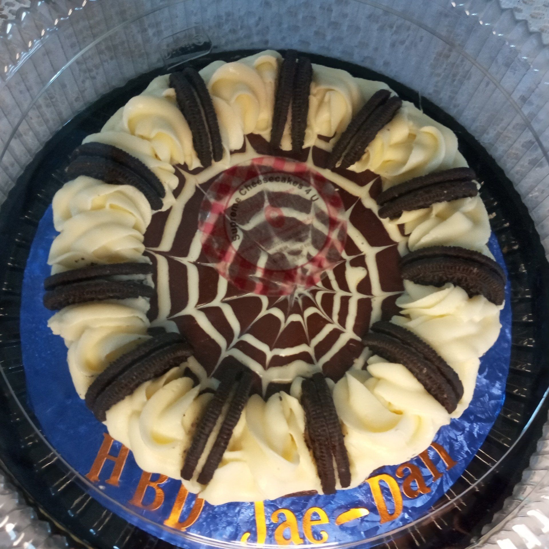 A cake in a plastic container with the name jae-dan on it