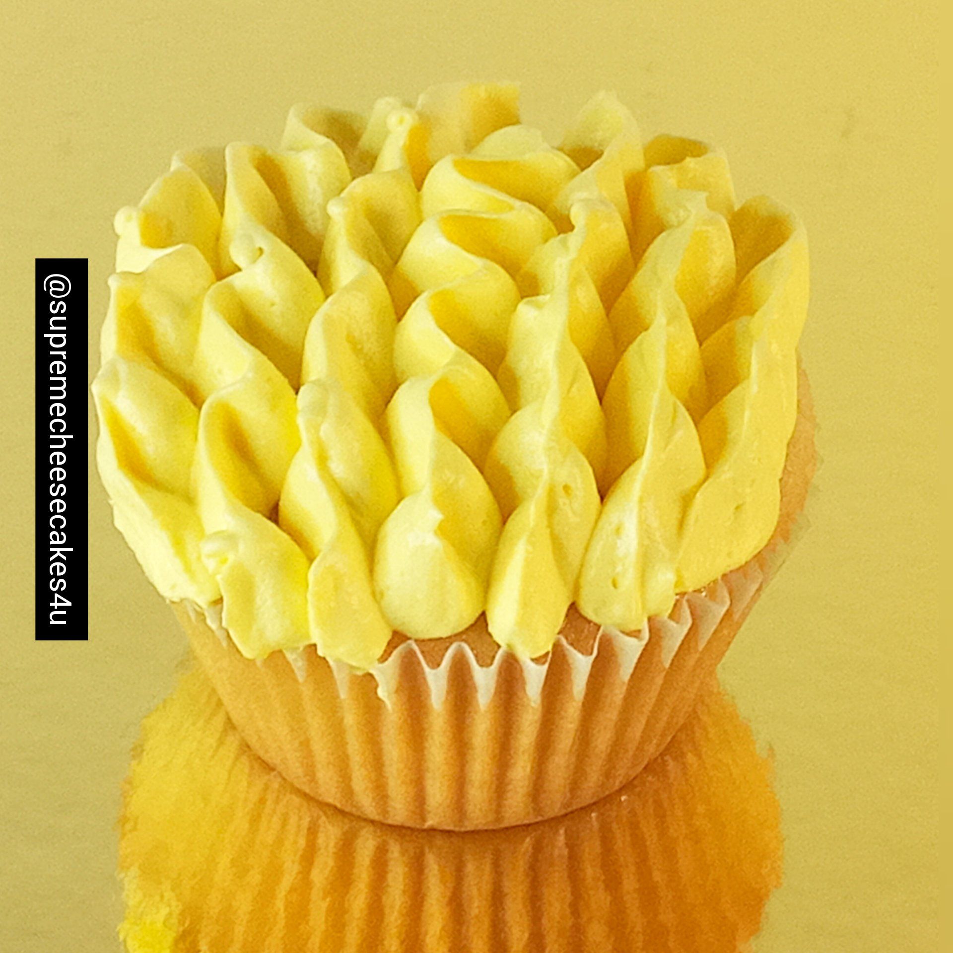 A close up of a cupcake with yellow frosting