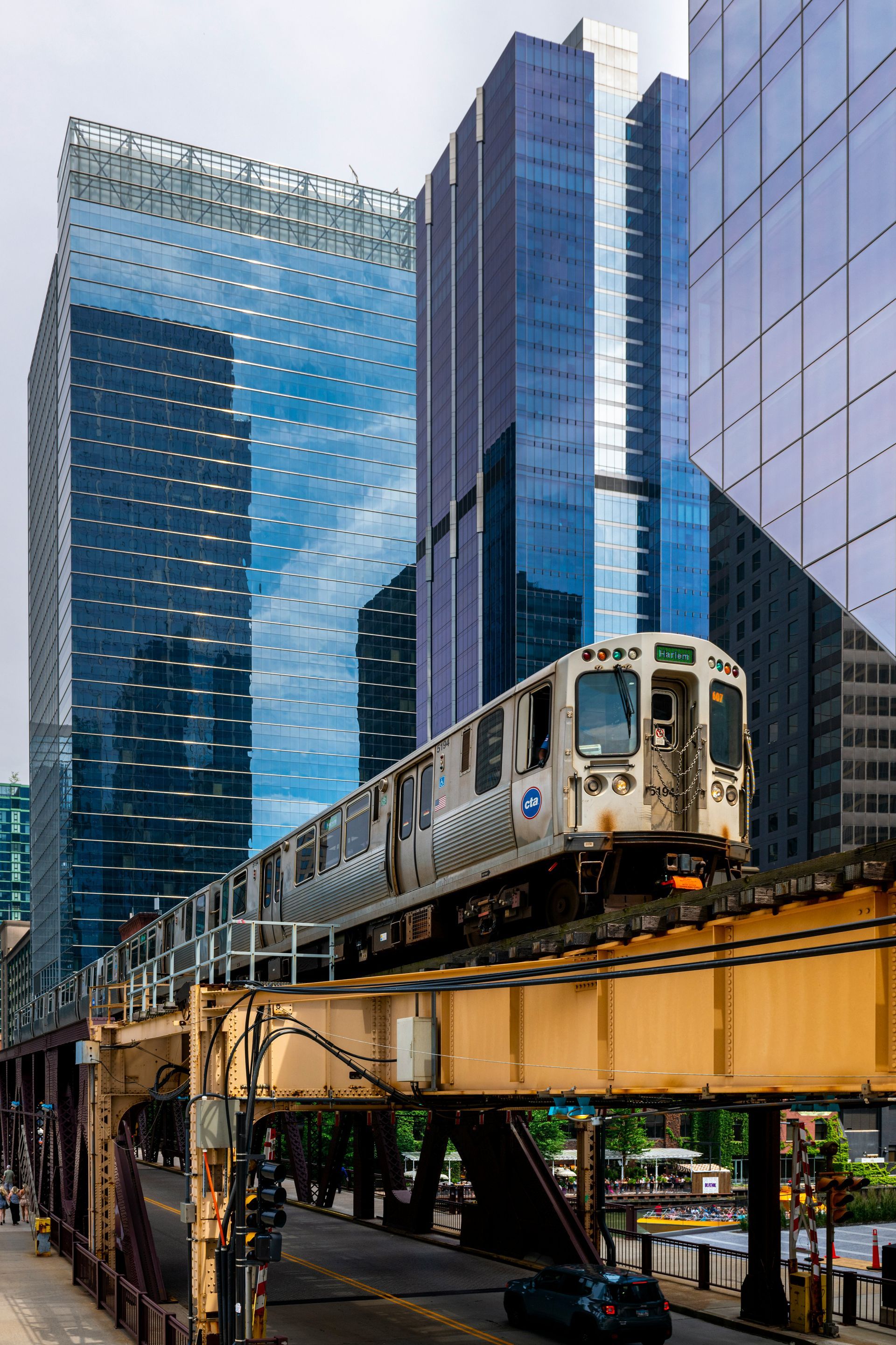 Train on elevated tracks in a city. Skyscrapers, blue glass. Sunny day.