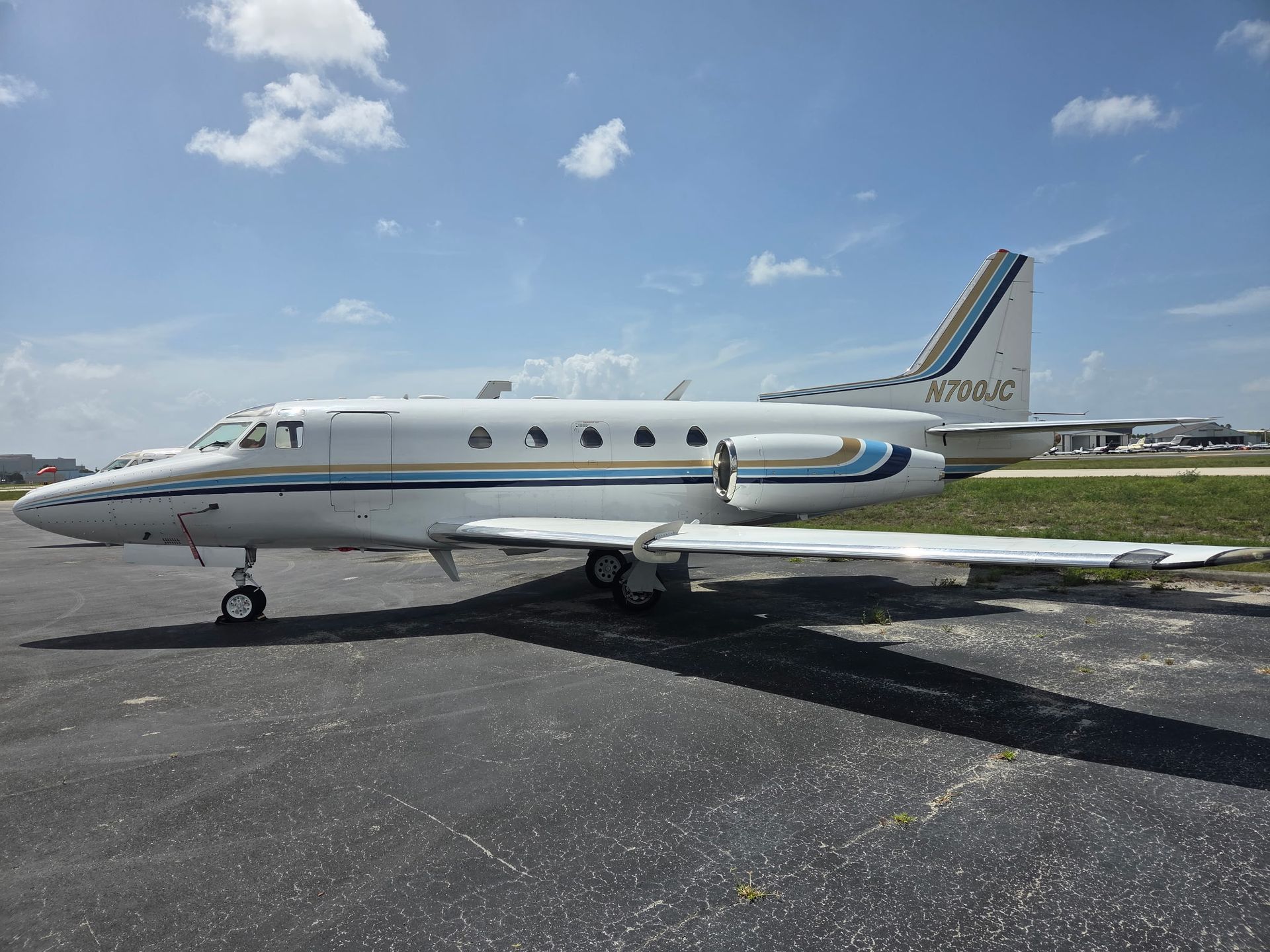 A small white airplane is parked on a runway.
