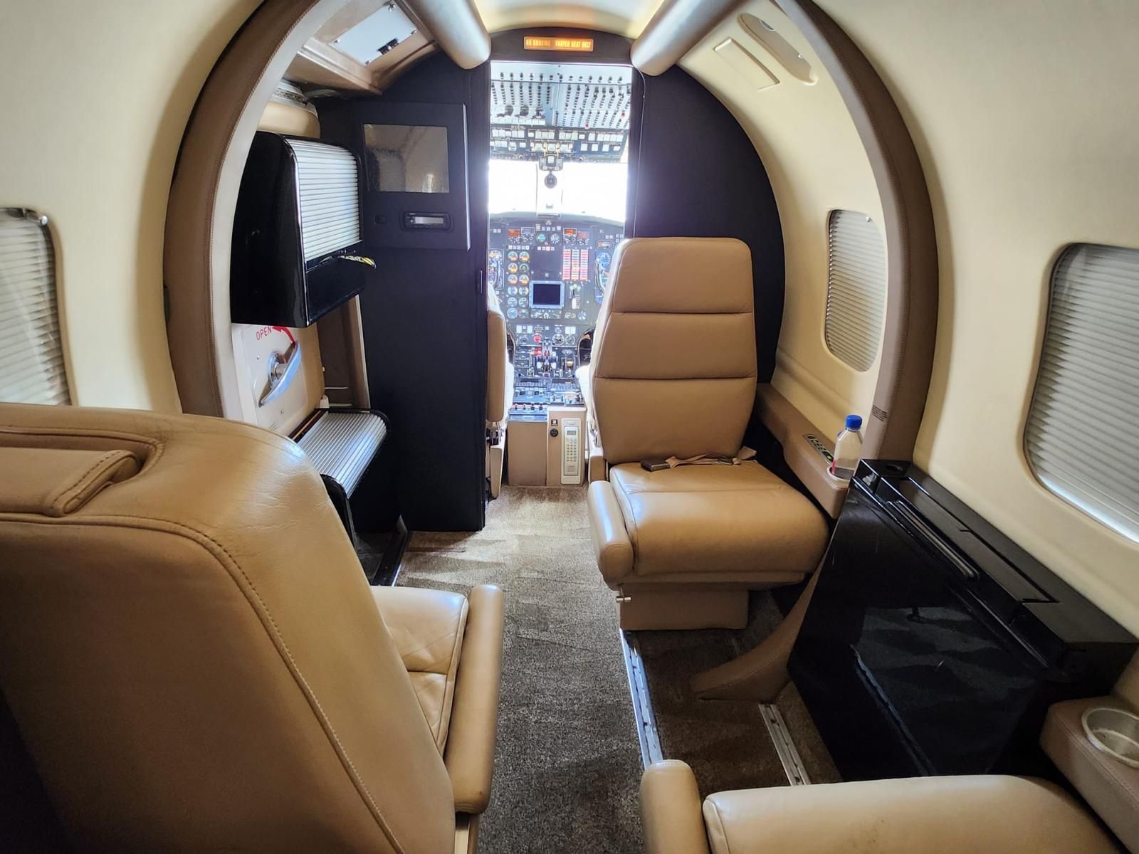 The inside of a private jet with tan leather seats