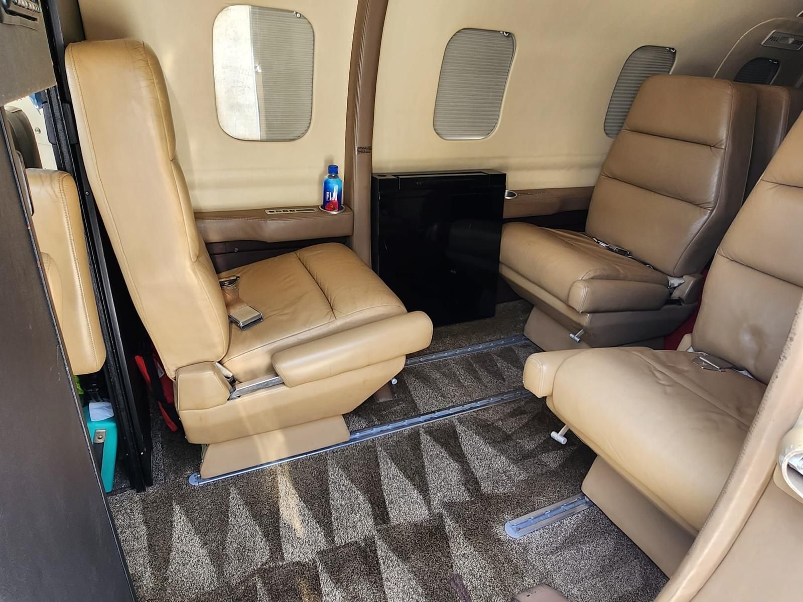 The inside of a private jet with tan leather seats