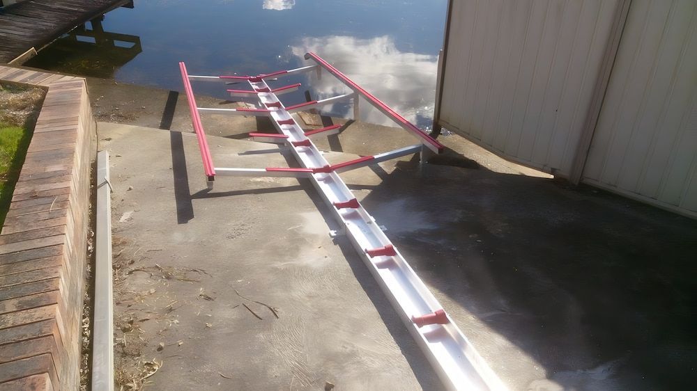 A Slipway is Sitting on the Ground Next to a Body of Water — Riverside Aluminium & Stainless in Forster, NSW
