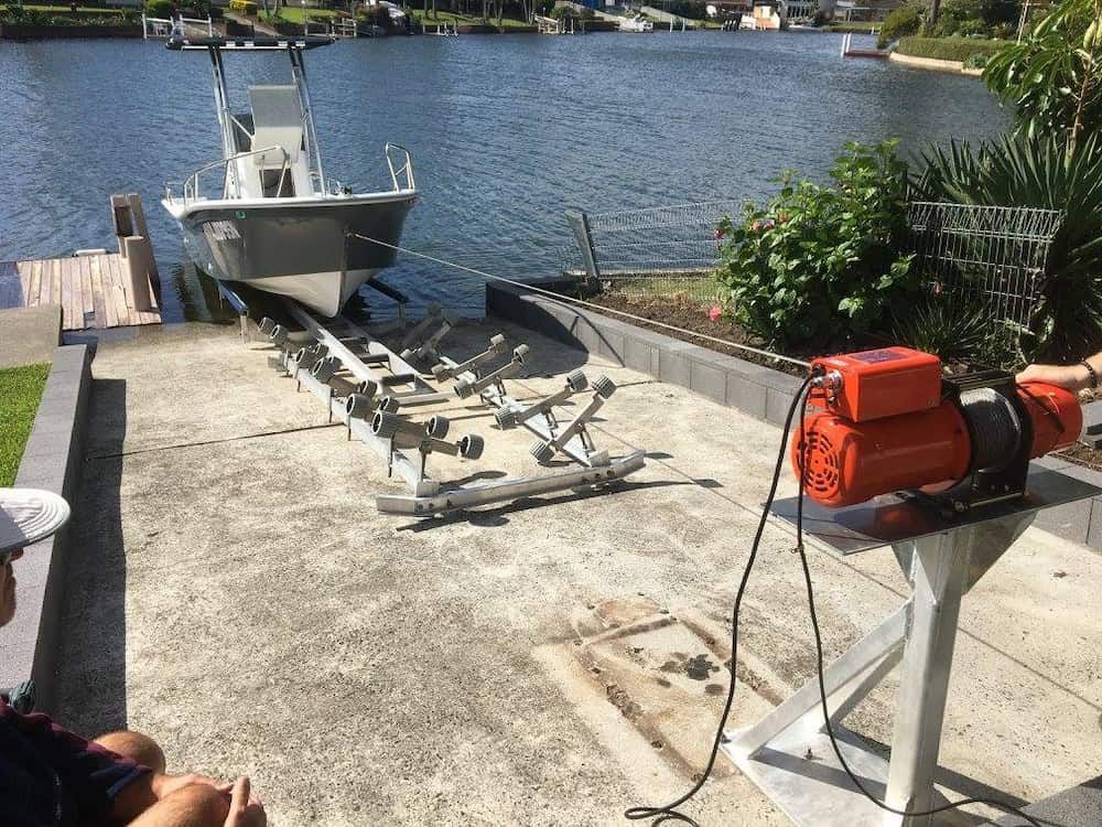 A Boat is Sitting on a Trailer Next to a Body of Water — Riverside Aluminium & Stainless in Coolongolook, NSW