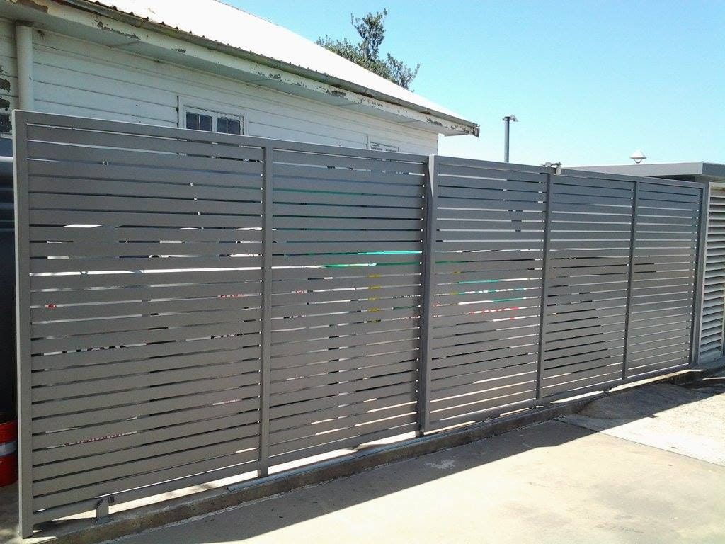A Metal Fence is Sitting in Front of a White Building — Riverside Aluminium & Stainless in Gloucester, NSW