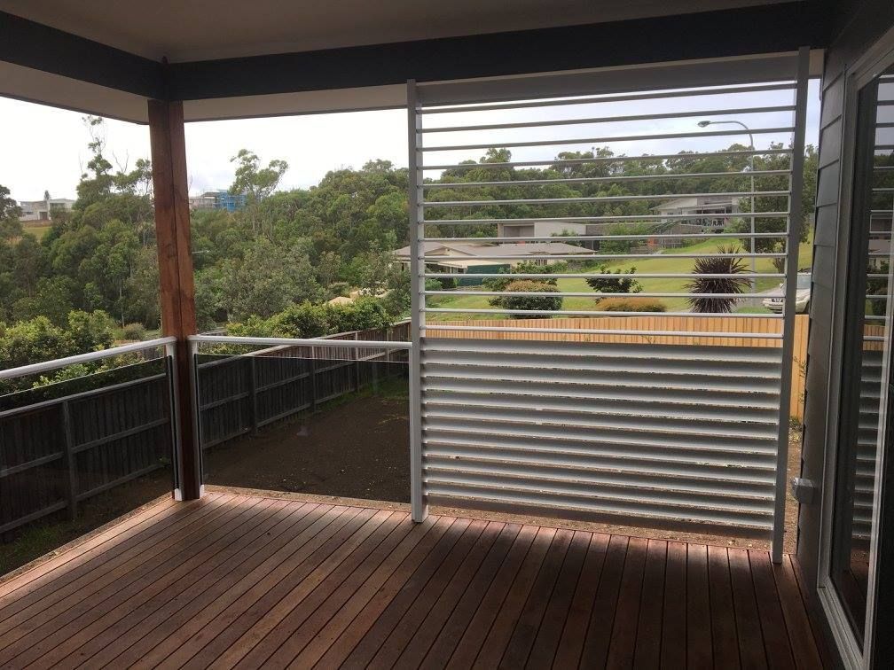 A Wooden Deck With a Metal Railing and a View of a Park — Riverside Aluminium & Stainless in Taree, NSW