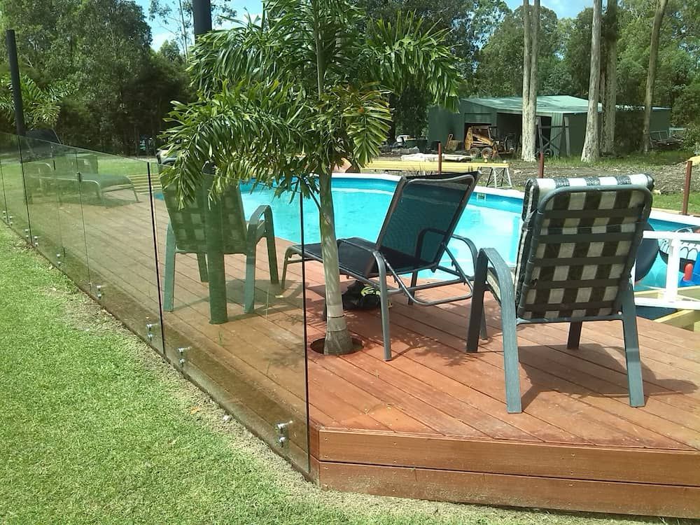 A Deck With Chairs and a Pool in the Background — Riverside Aluminium & Stainless in Harrington, NSW