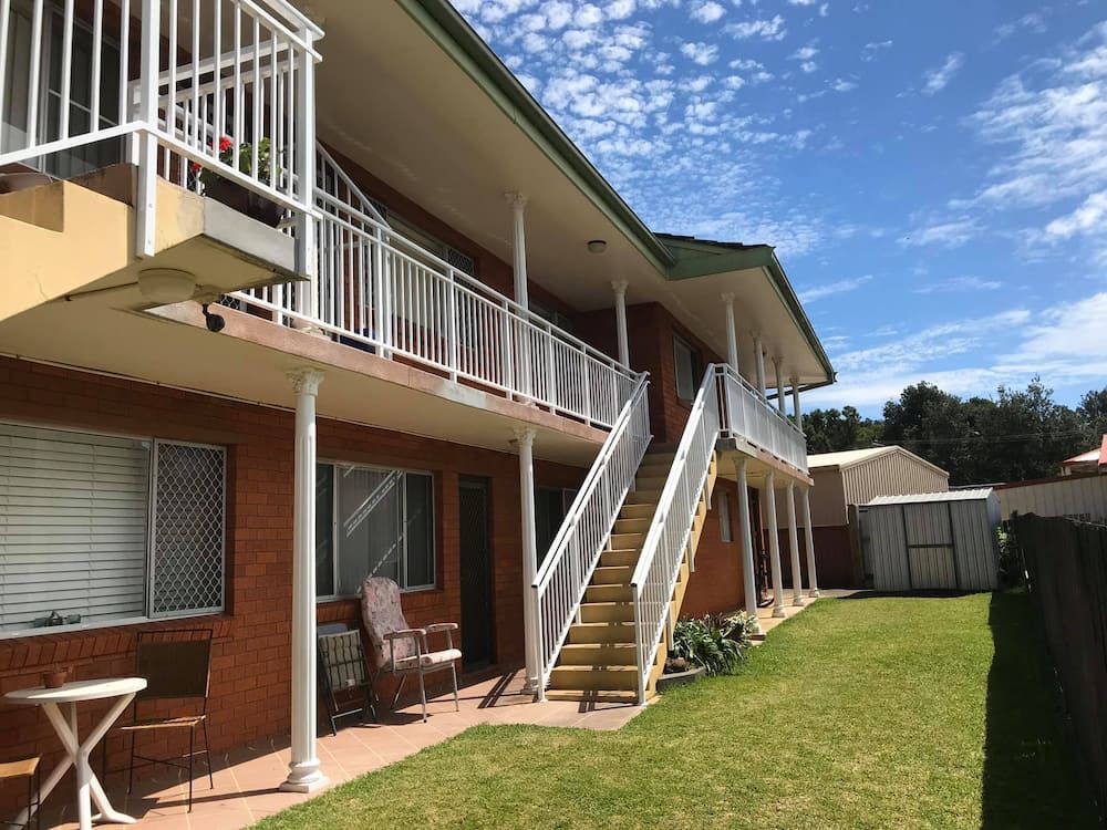 A Brick Apartment Building With Stairs Leading Up to the Second Floor — Riverside Aluminium & Stainless in Coolongolook, NSW