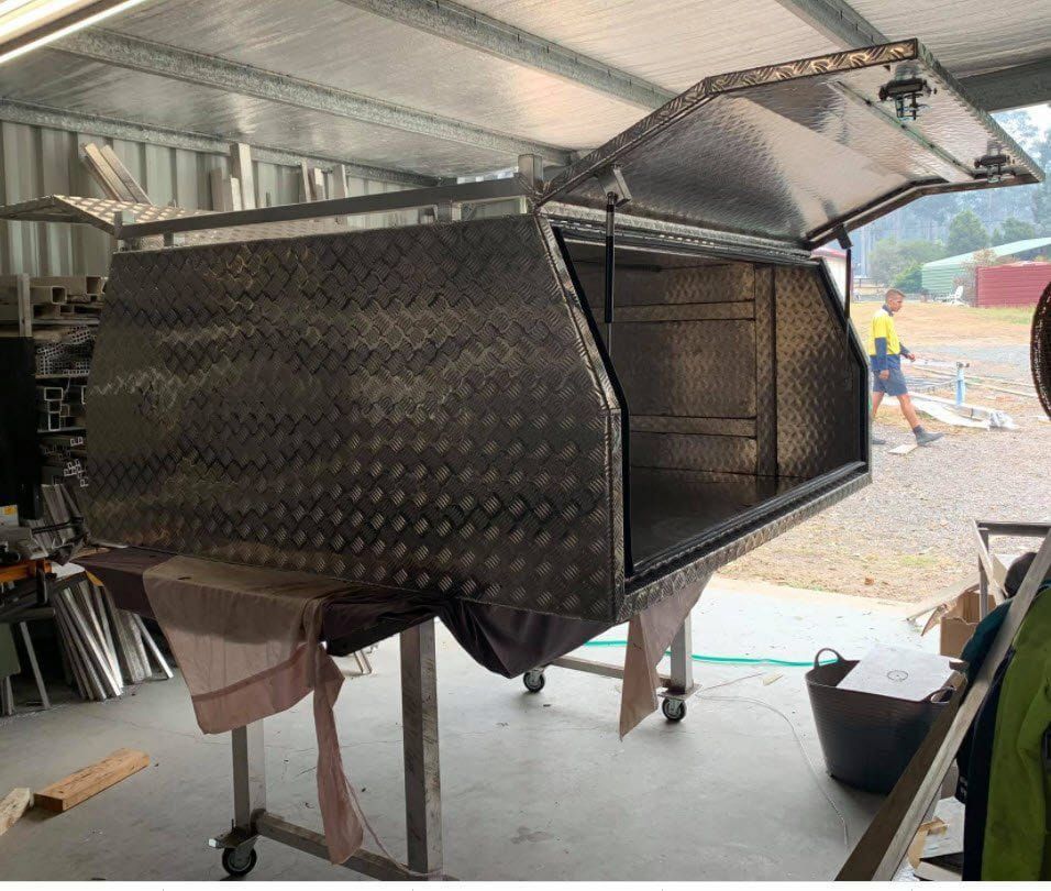 A Stainless Steel Canopy is Sitting on a Table in a Garage — Riverside Aluminium & Stainless in Coolongolook, NSW