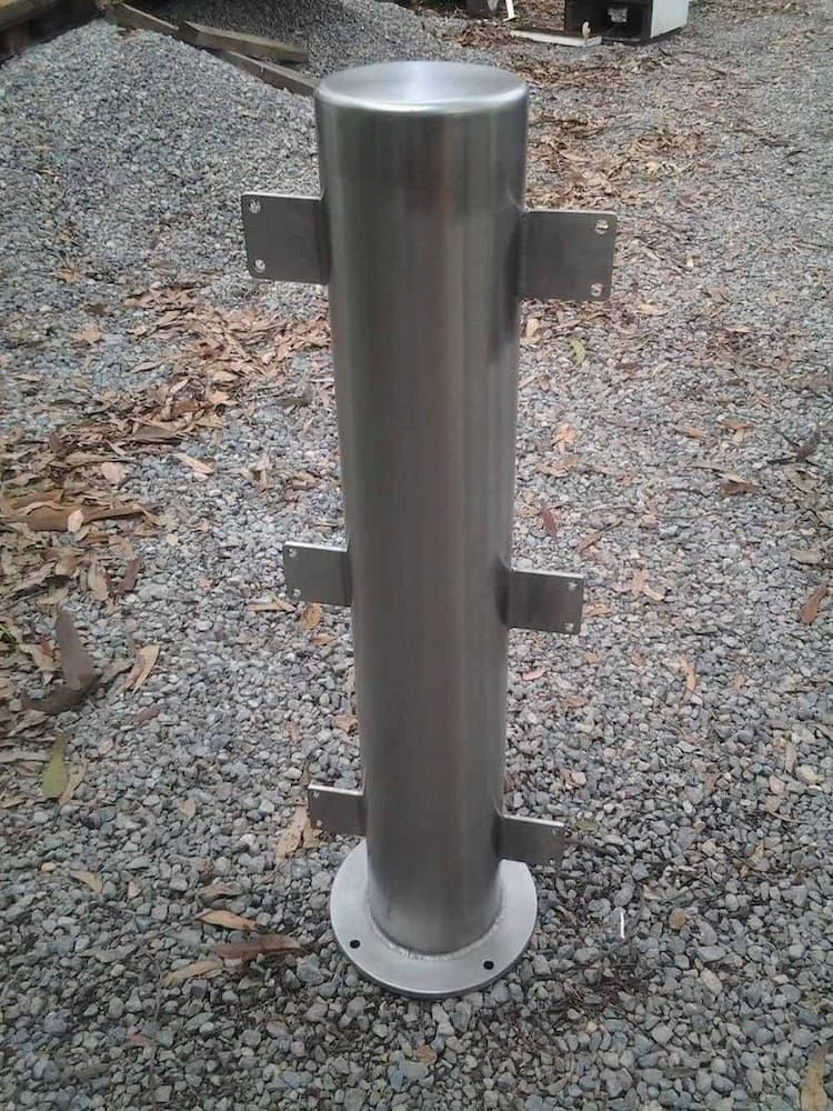 A Stainless Steel Pole is Sitting on a Gravel Road — Riverside Aluminium & Stainless in Taree, NSW
