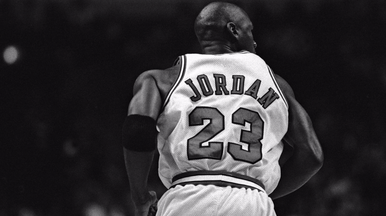 Michael Jordan, joueur des Chicago Bulls, vue de dos, portant le maillot numéro 23, regardant ailleurs.
