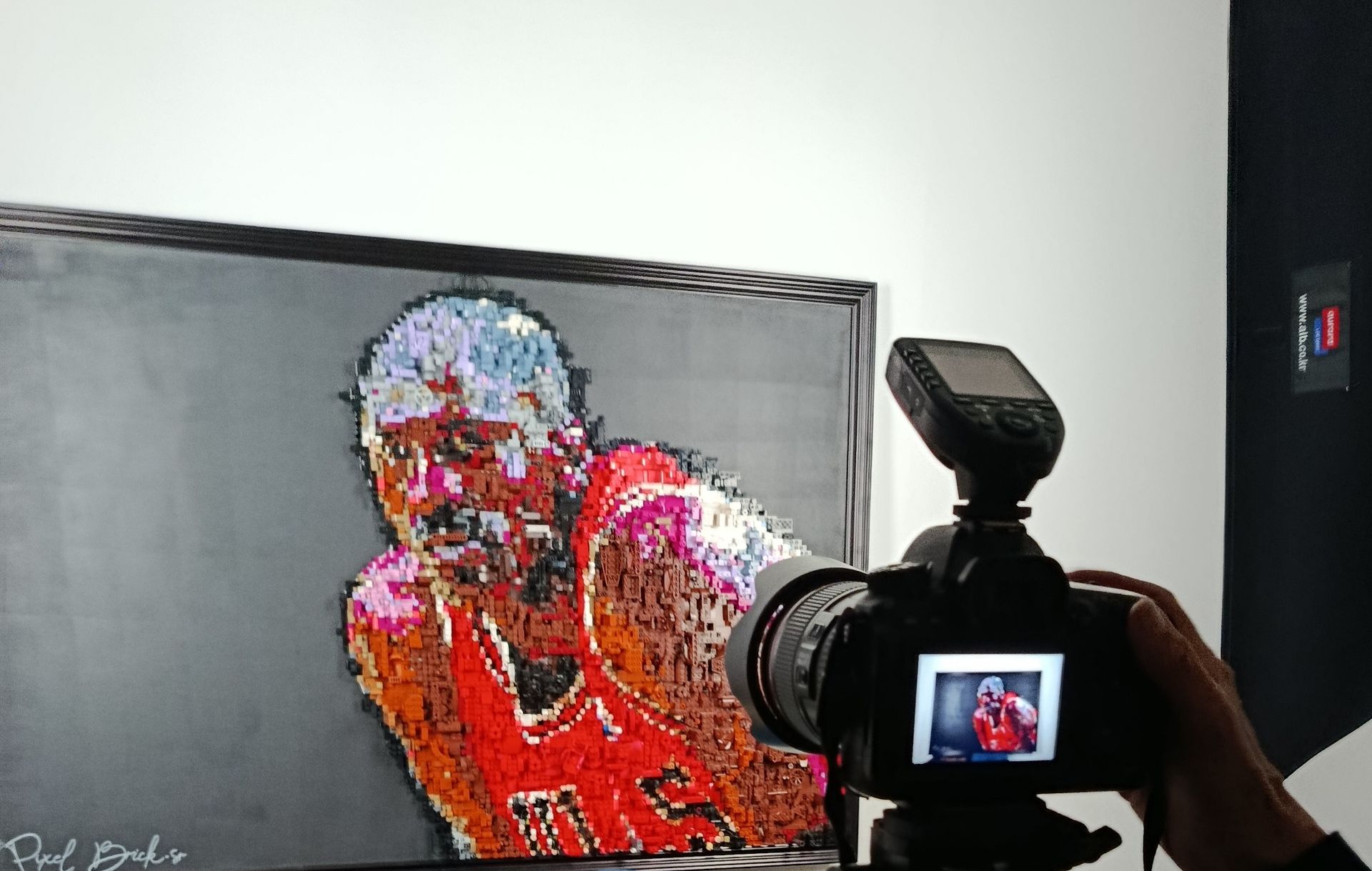 Appareil photo prenant une photo d'une peinture pop art colorée de Michael Jordan dans une galerie.