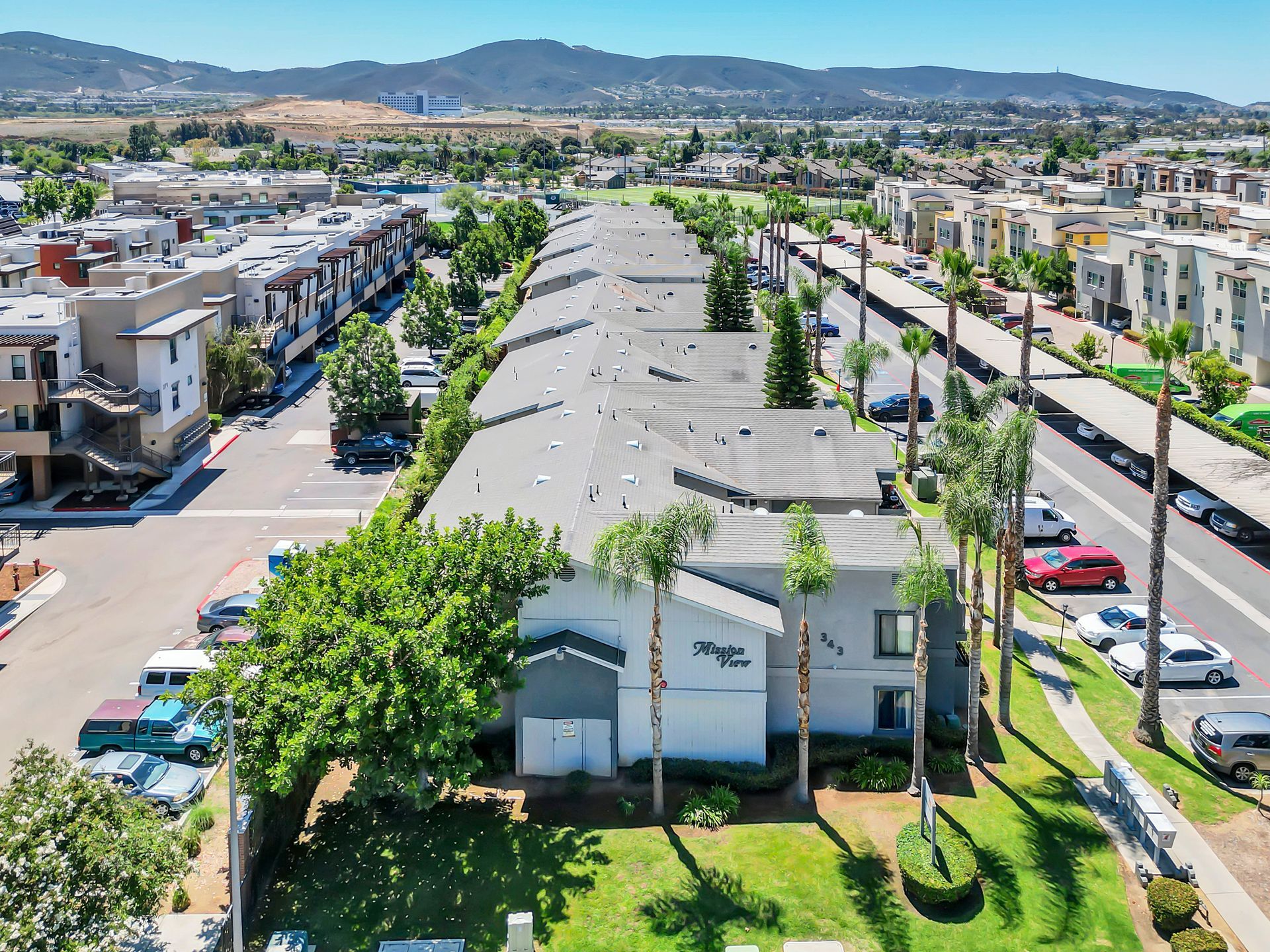 An aerial view of a residential area with lots of buildings and palm trees