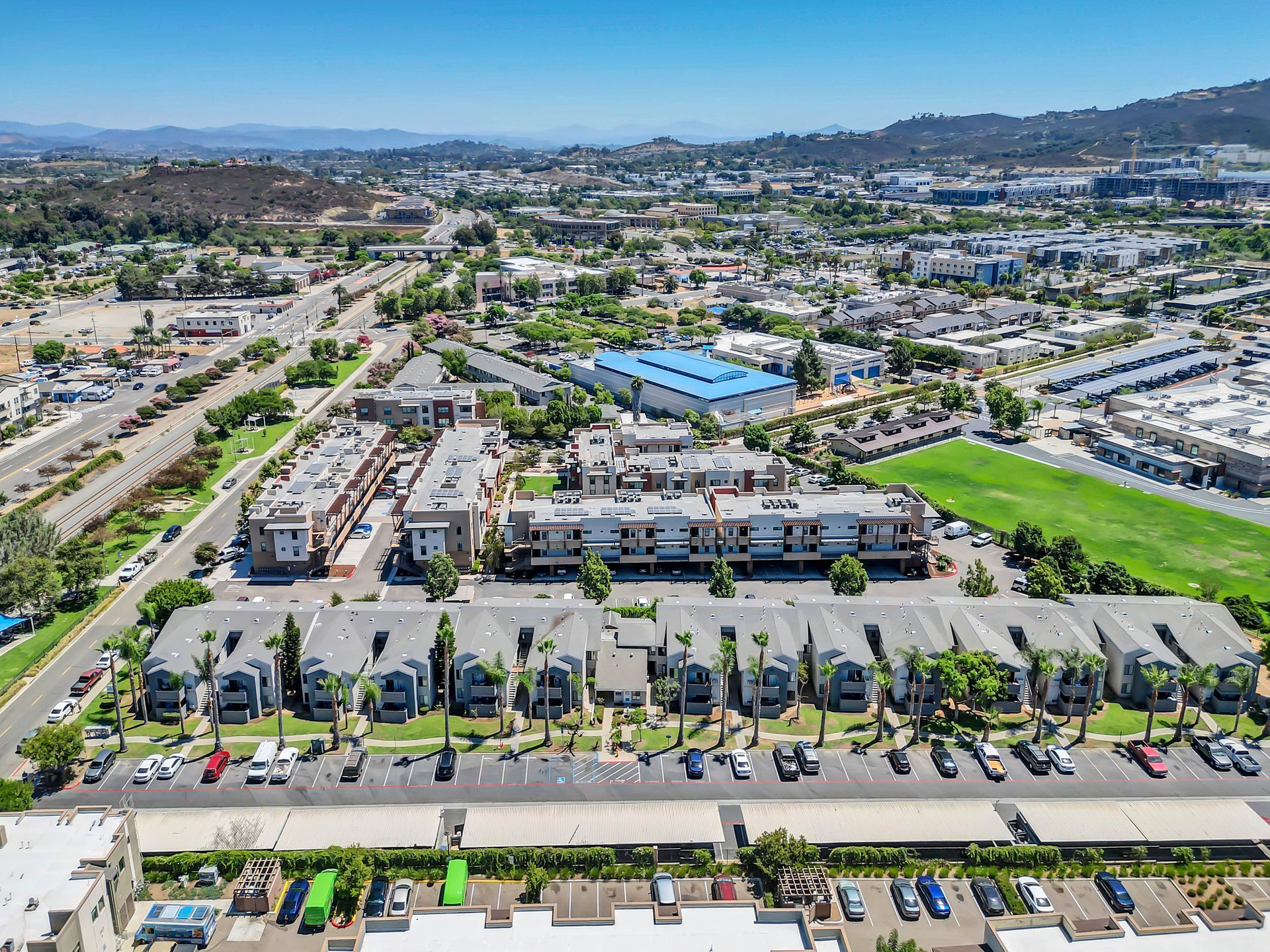 An aerial view of a residential area with a lot of cars parked in front of it.