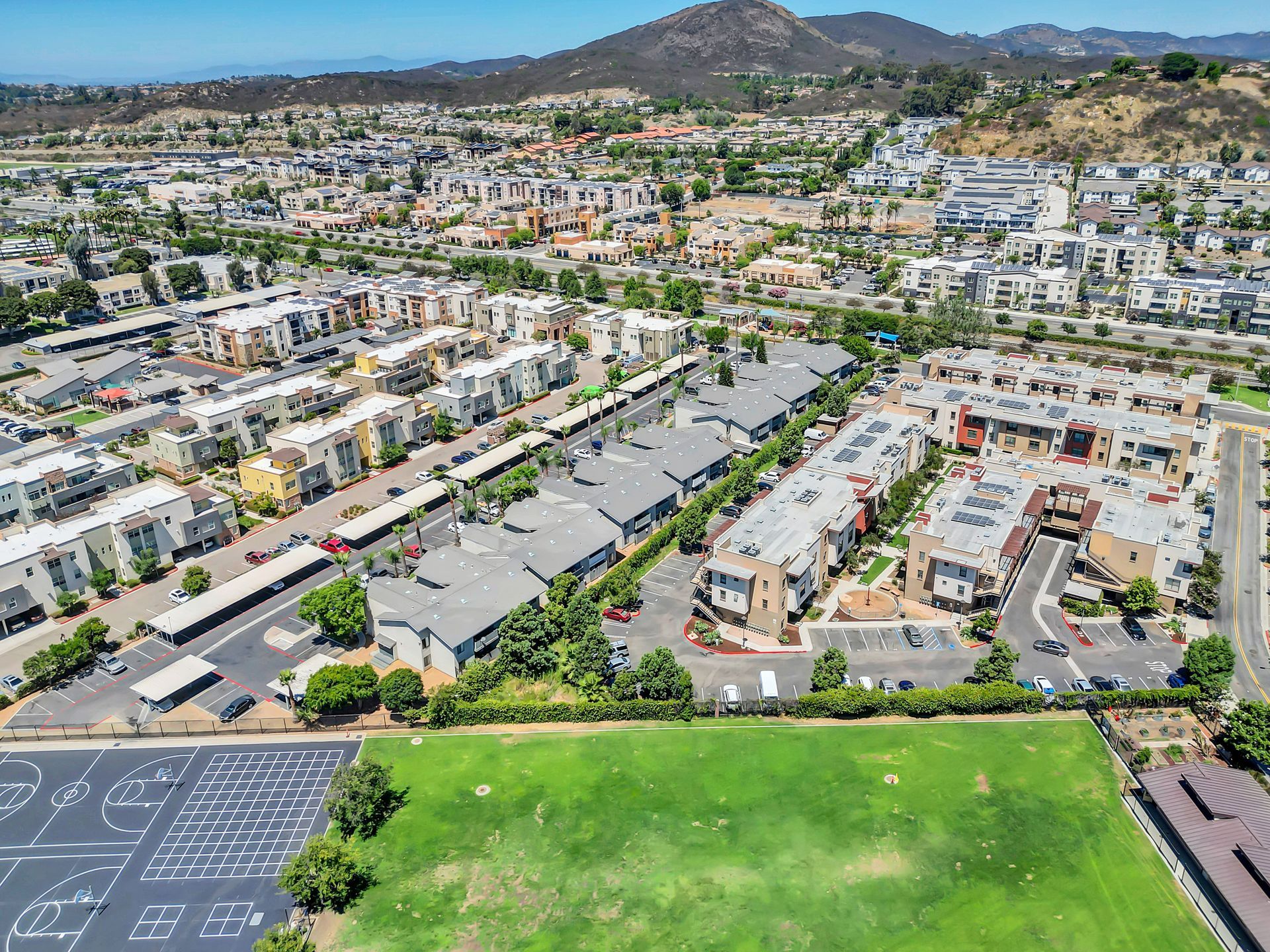 An aerial view of a residential area with a basketball court in the foreground.