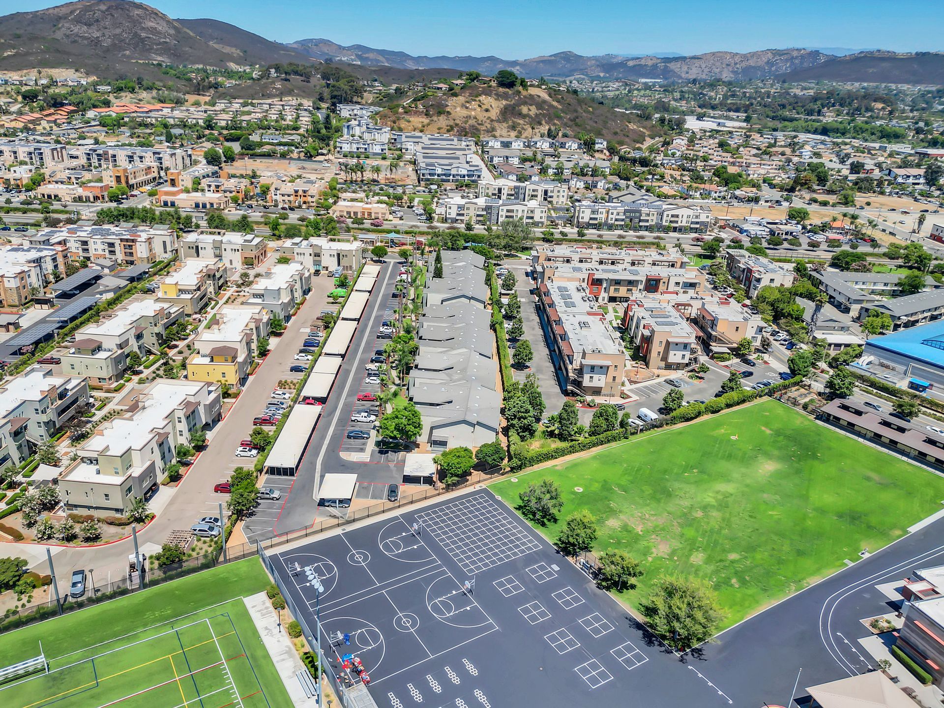 An aerial view of a city with a tennis court in the foreground.