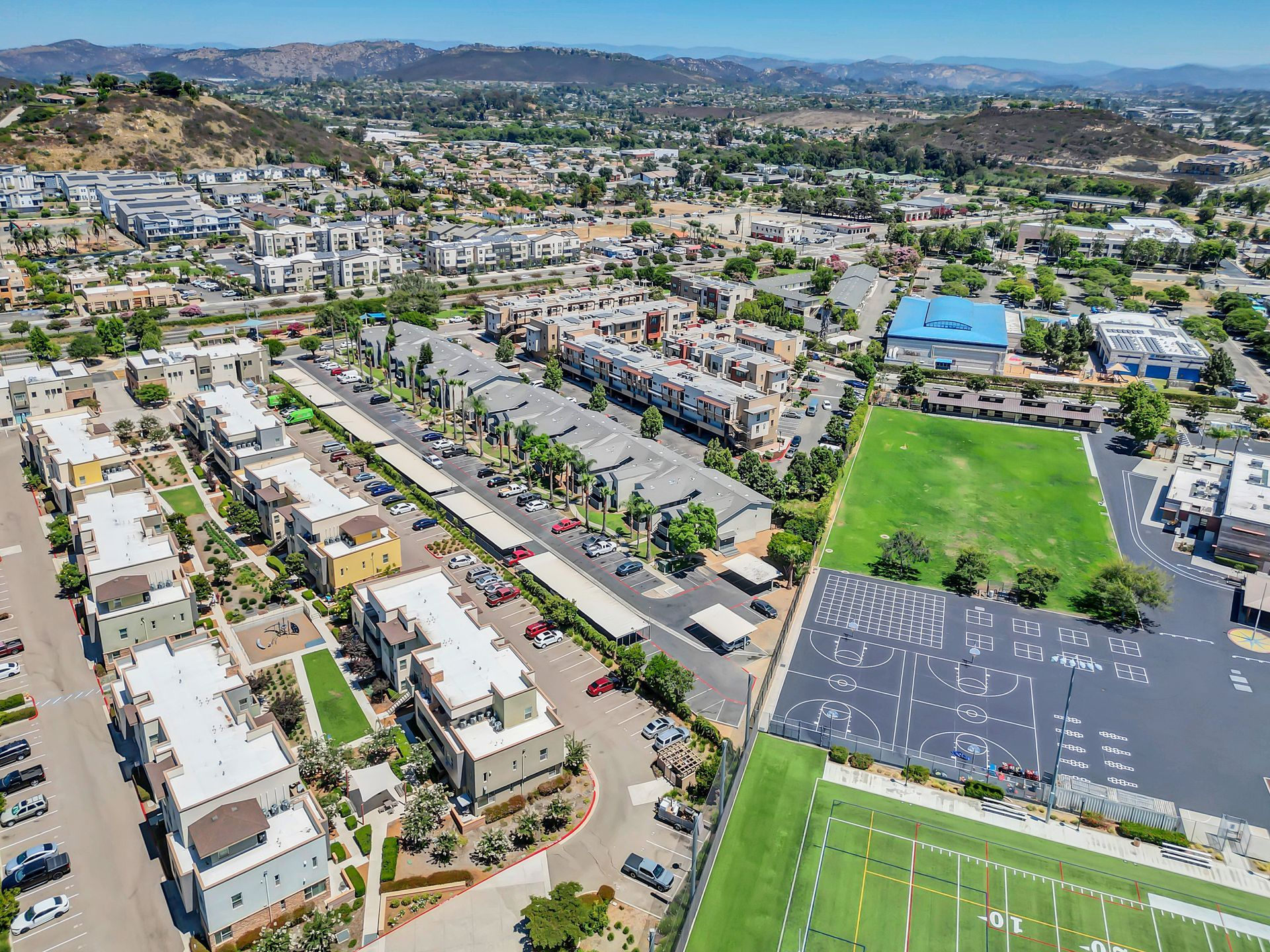 An aerial view of a city with a football field in the foreground.