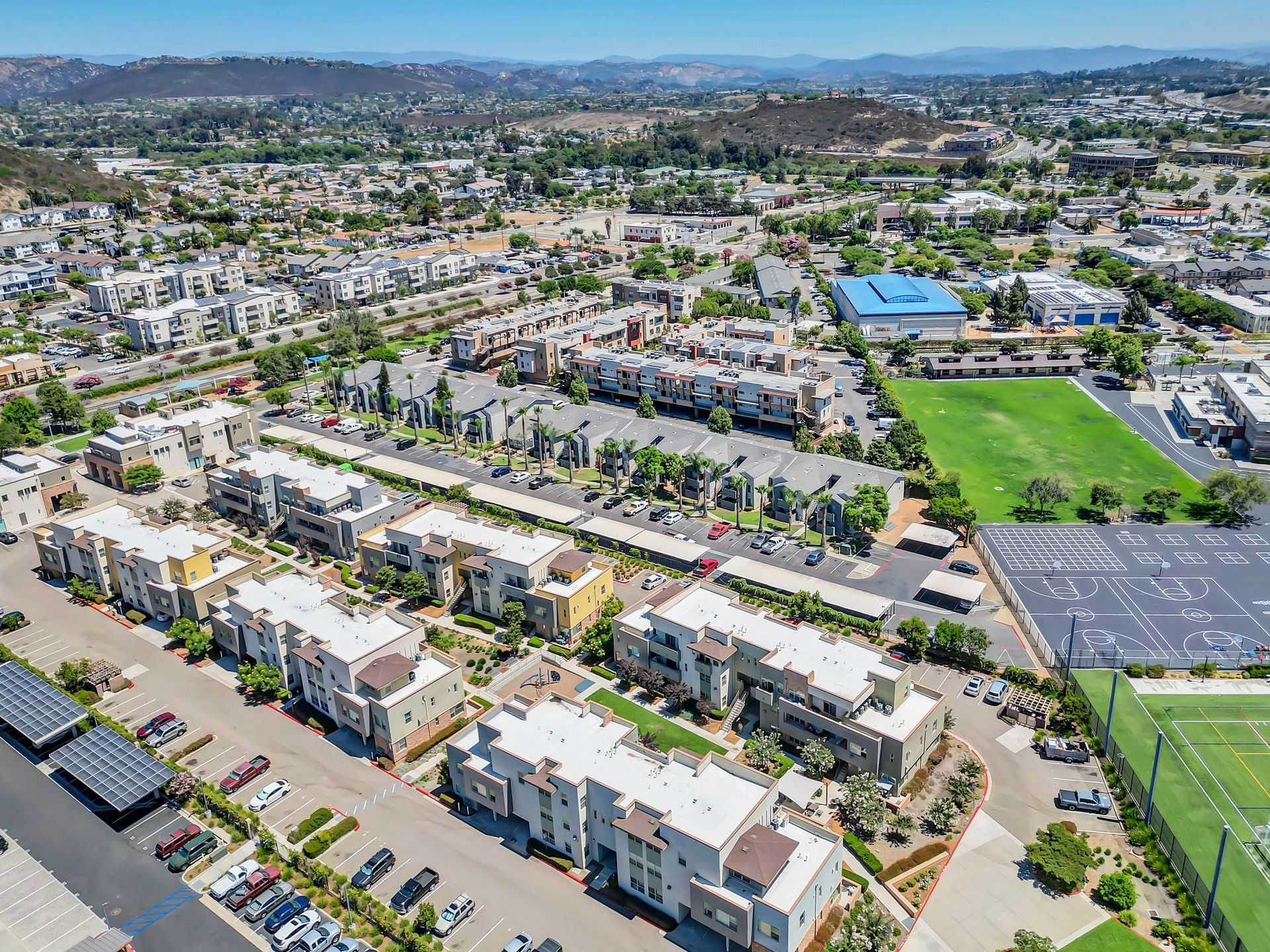 An aerial view of a residential area with lots of buildings and a soccer field.
