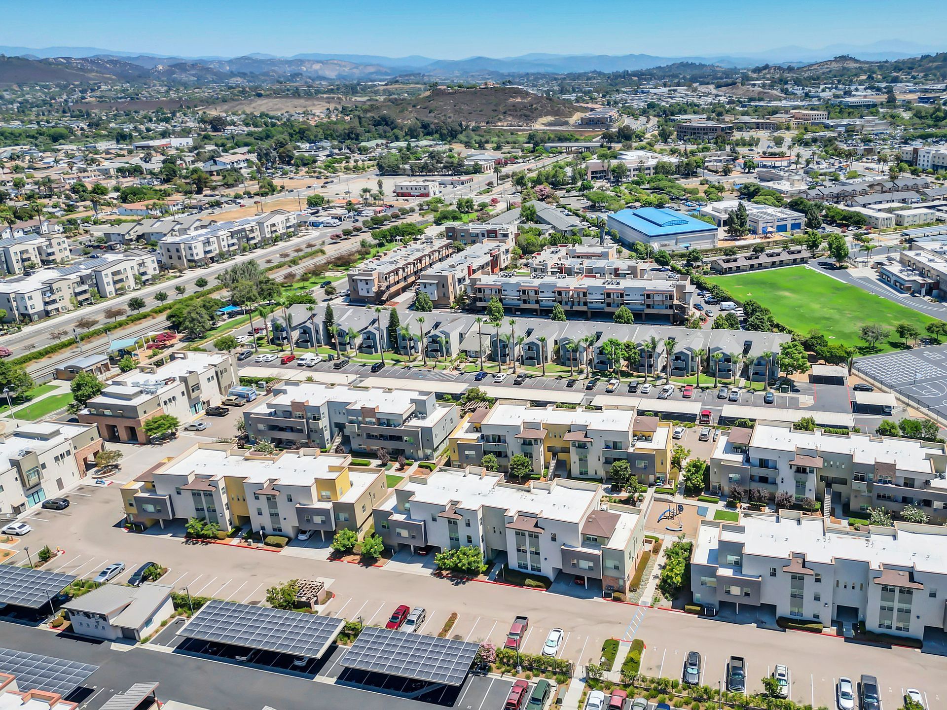 An aerial view of a residential area with lots of buildings and parking lots.