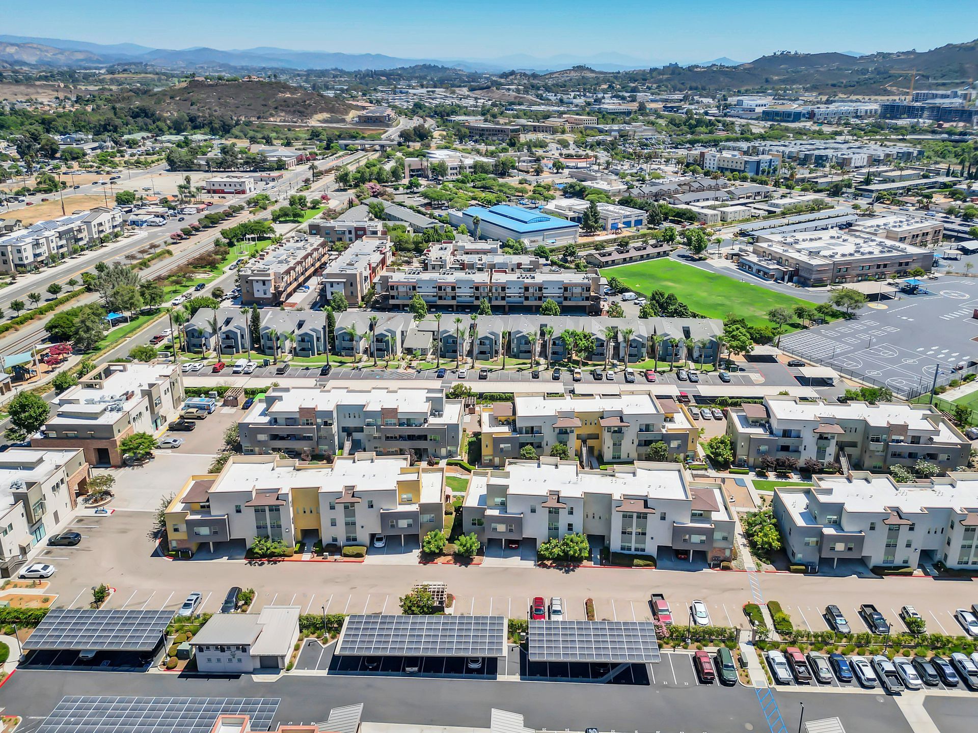 An aerial view of a residential area with lots of buildings and a parking lot.