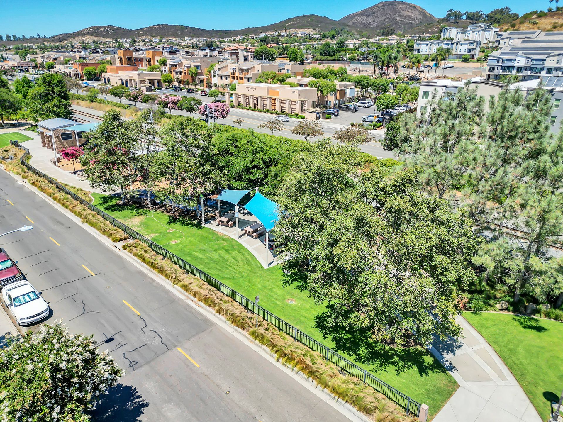 An aerial view of a park with a blue umbrella in the middle