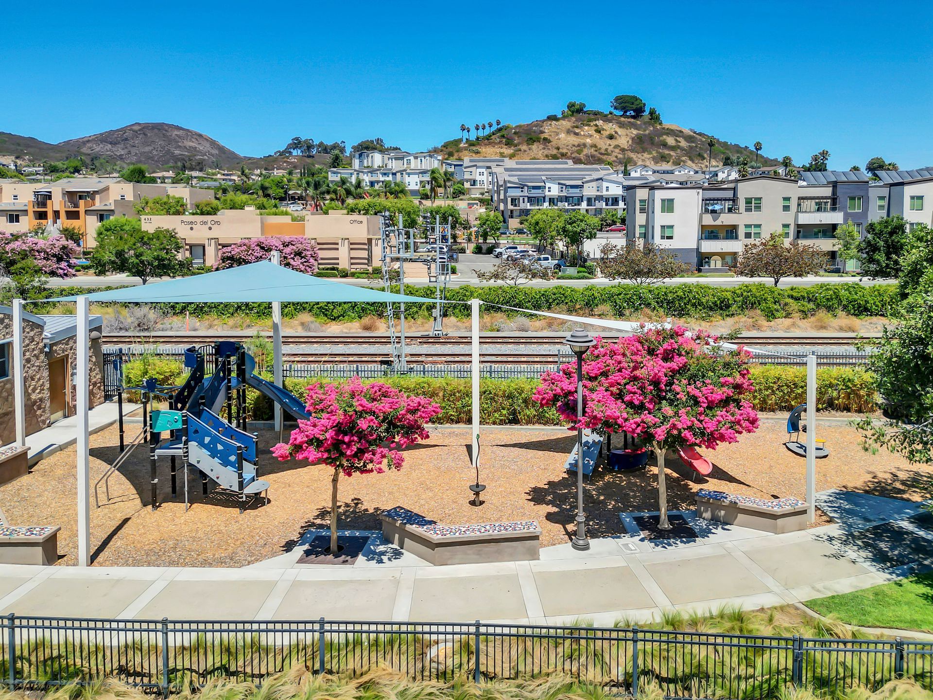 An aerial view of a park with a playground and trees.