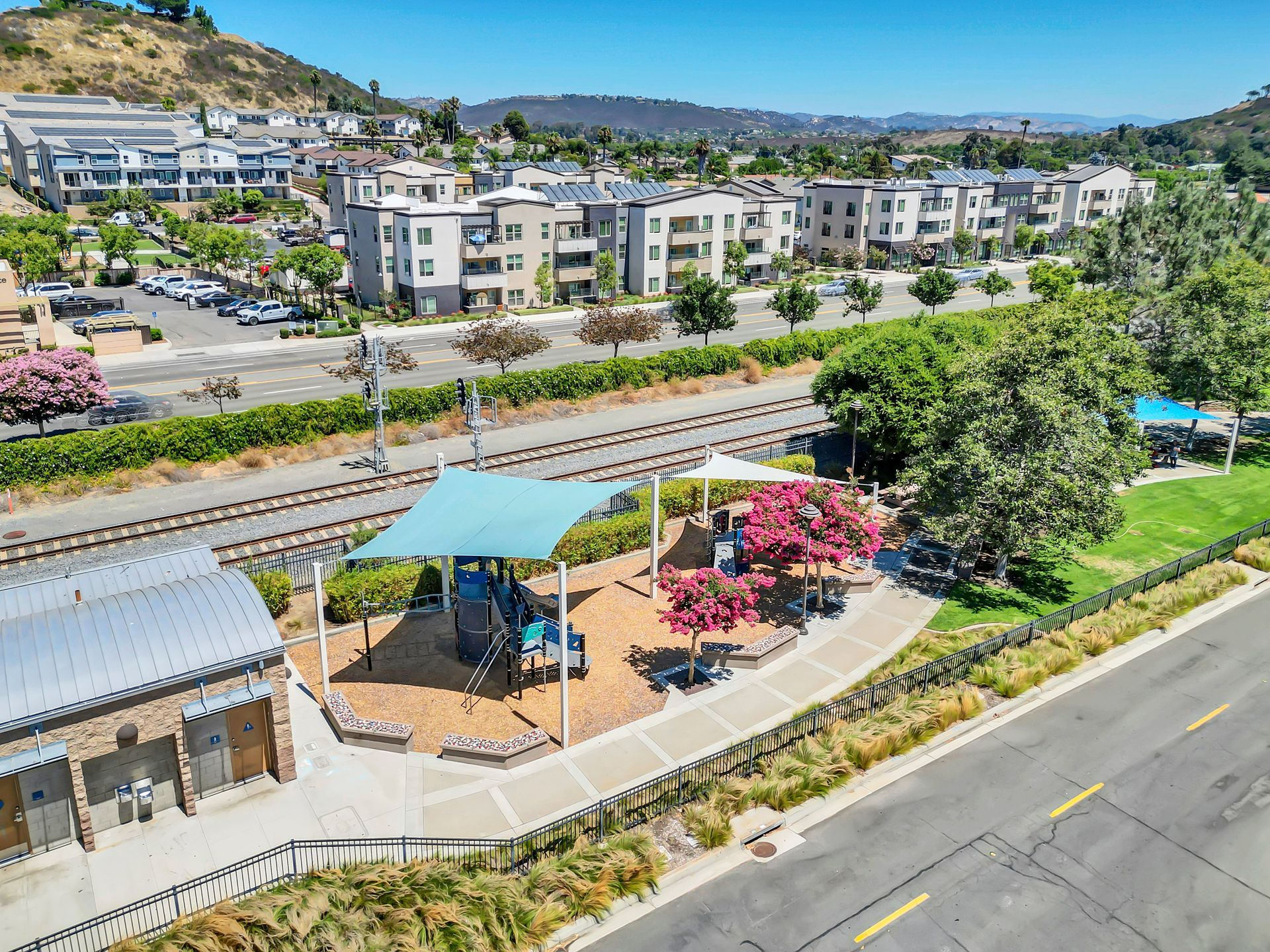 An aerial view of a park next to a train track.
