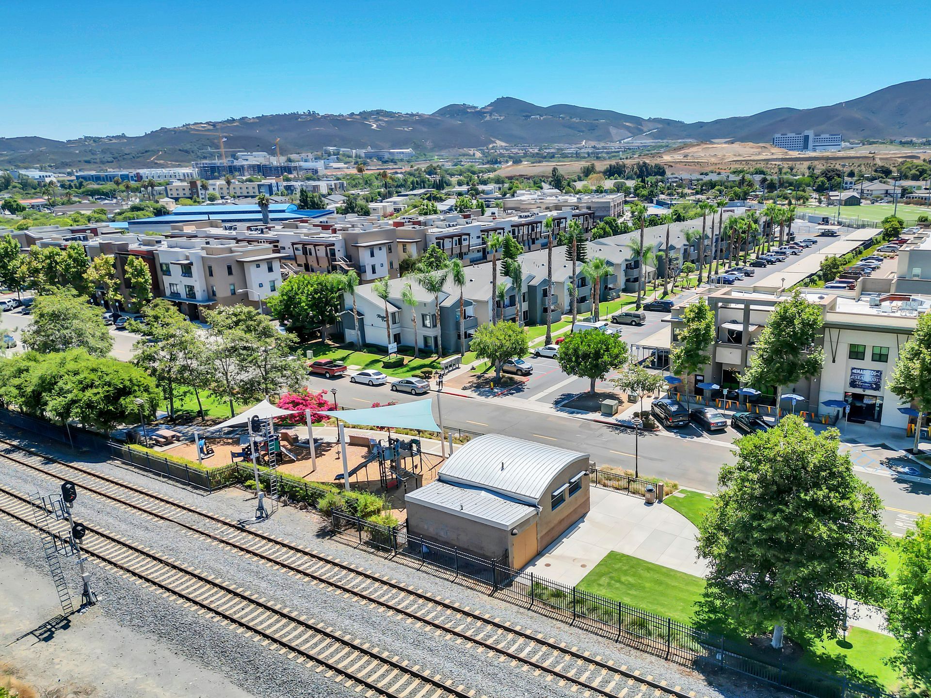 An aerial view of a city with a train track in the foreground.